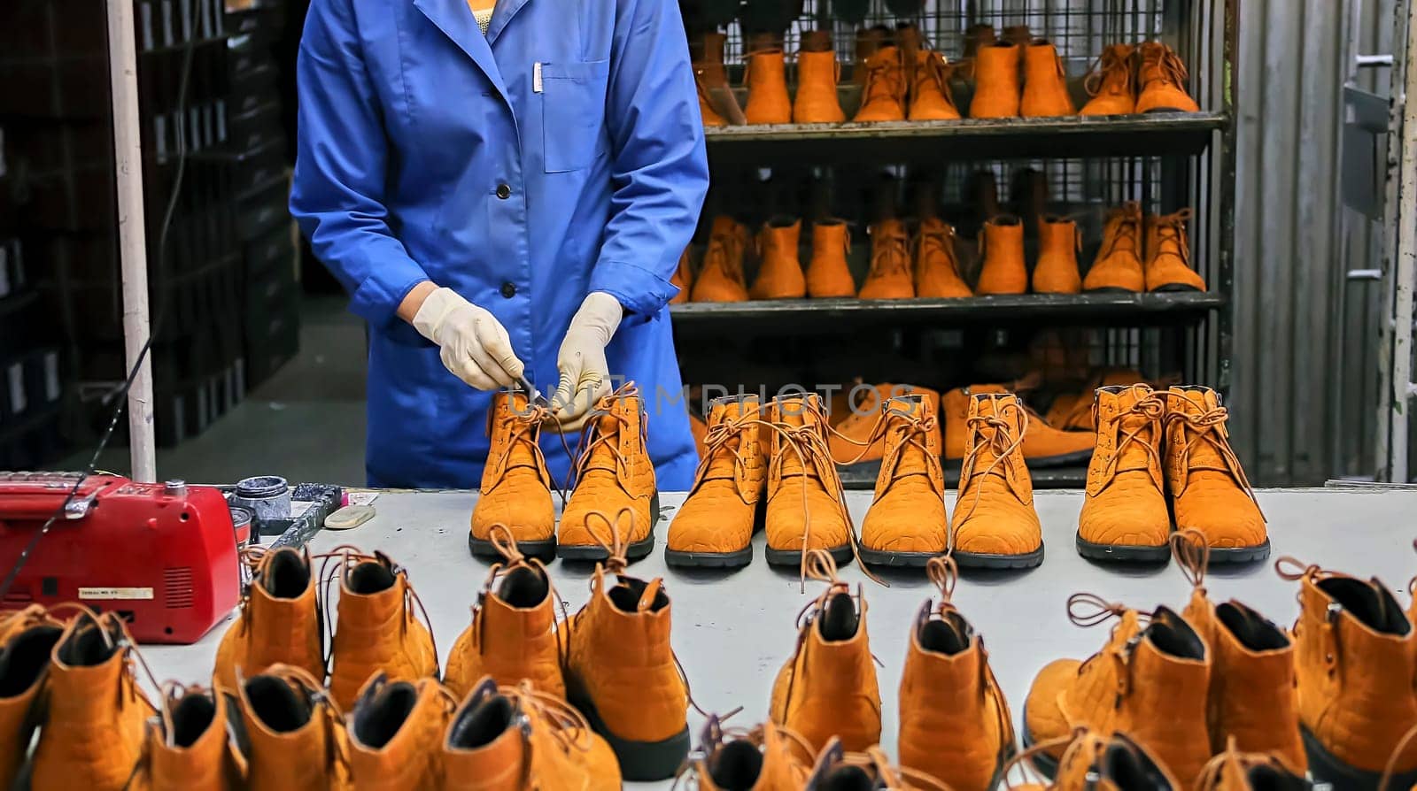 Checking the quality of shoes in a shoe factory. Yellow boots, finished shoes.