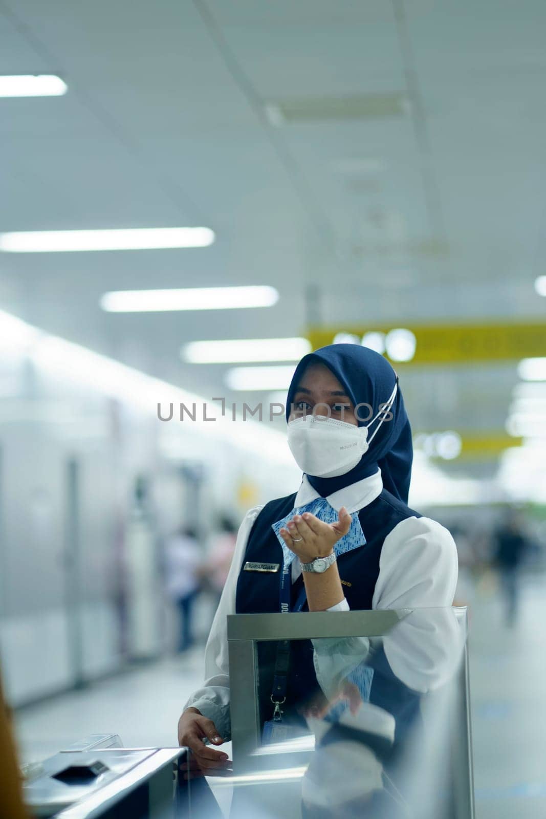 Friendly female officer greeting the passengers at the entry gate at MRT Station, Jakarta. Indonesia. April 20, 2023. Public service photography.