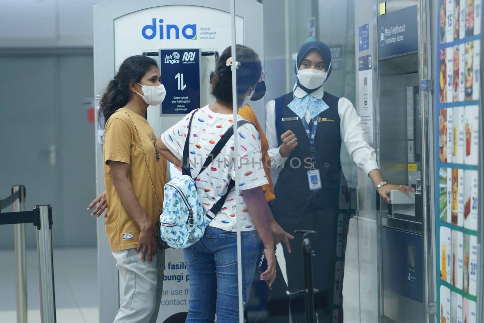 An officer is helping people at the ticket machine at the MRT Station, Jakarta, Indonesia. April 20, 2023. Publice service photography.