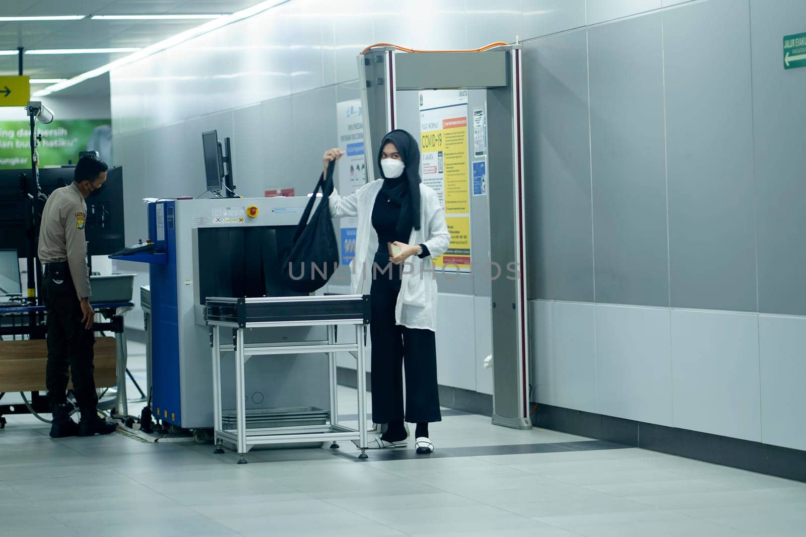Security check at MRT Station, Jakarta, Indonesia with male officer and female passanger. April 20, 2023. Publice service photography.