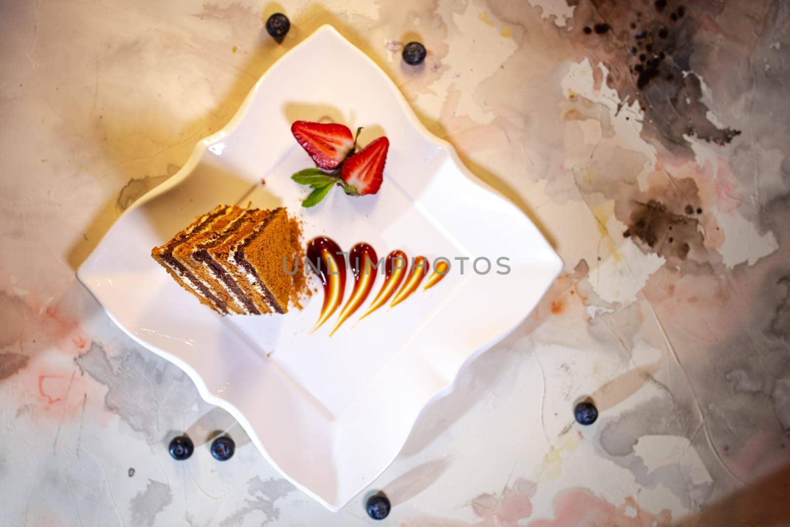 layered honey cake on a white plate top view.