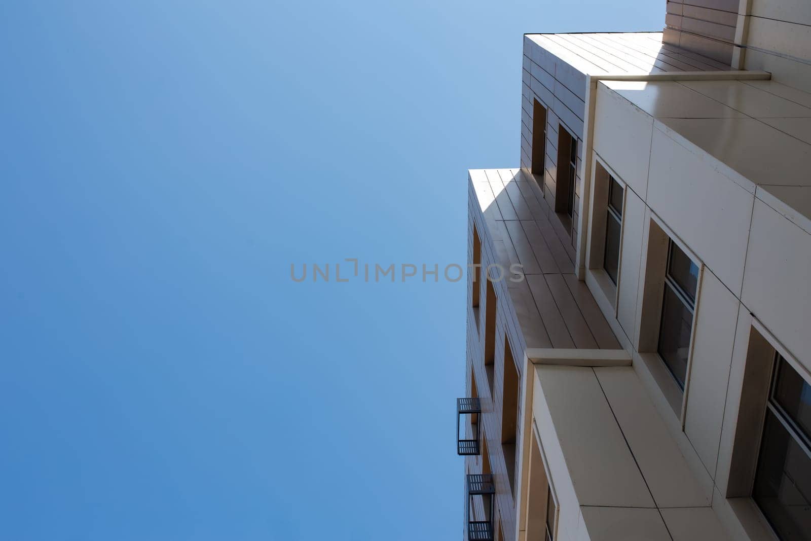 bottom view of a multi-storey building and the sky background.