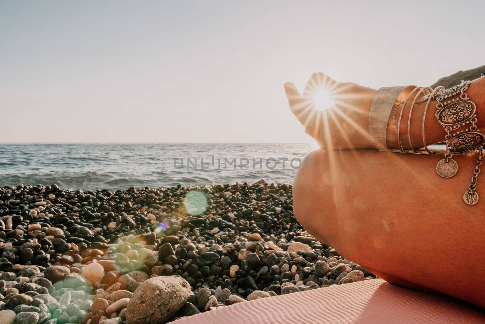 Woman sea yoga. Happy woman in white swimsuit and boho style braclets practicing outdoors on yoga mat by sea on sunset. Women yoga fitness routine. Healthy lifestyle, harmony and meditation by panophotograph