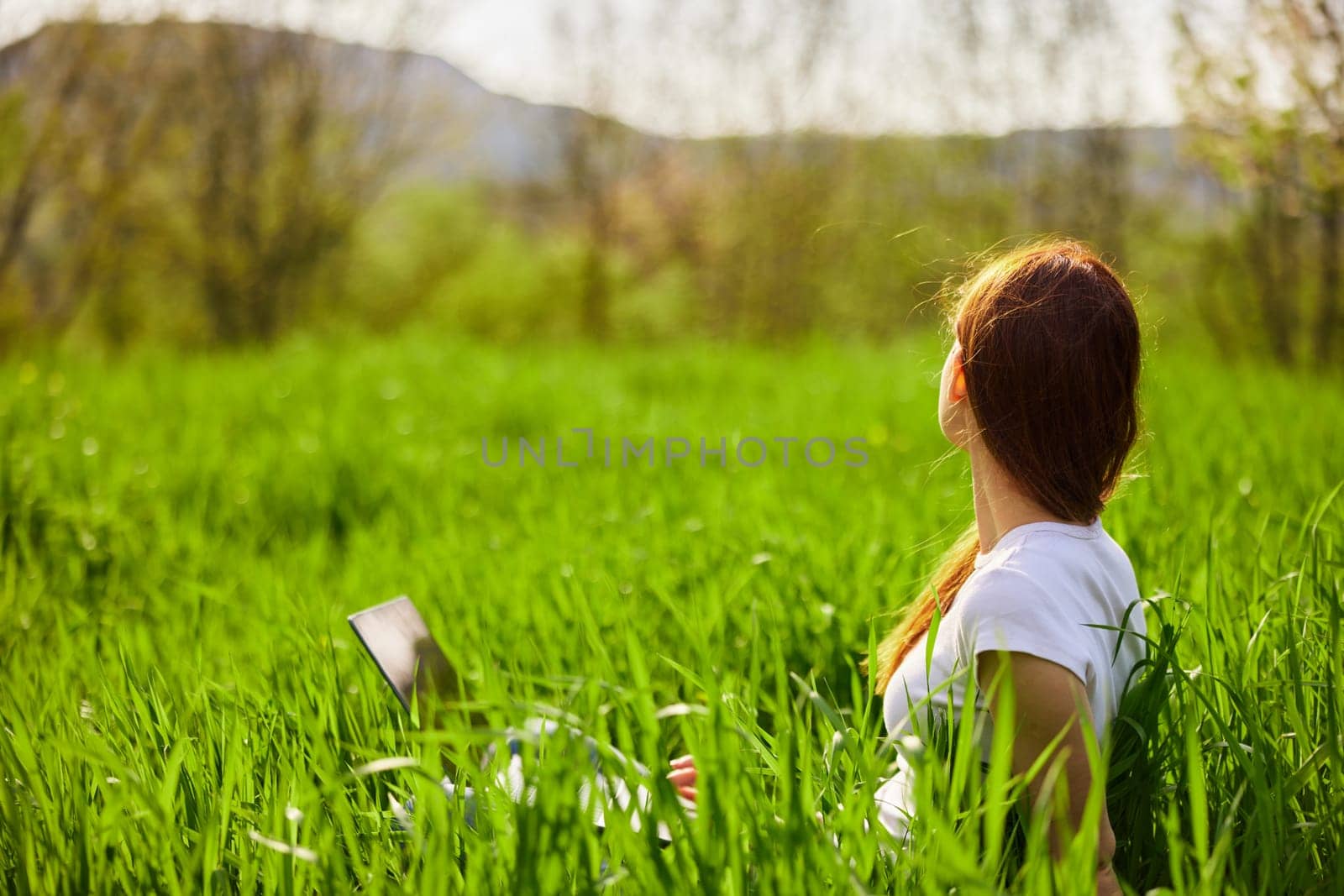 Woman with laptop working in park by Vichizh