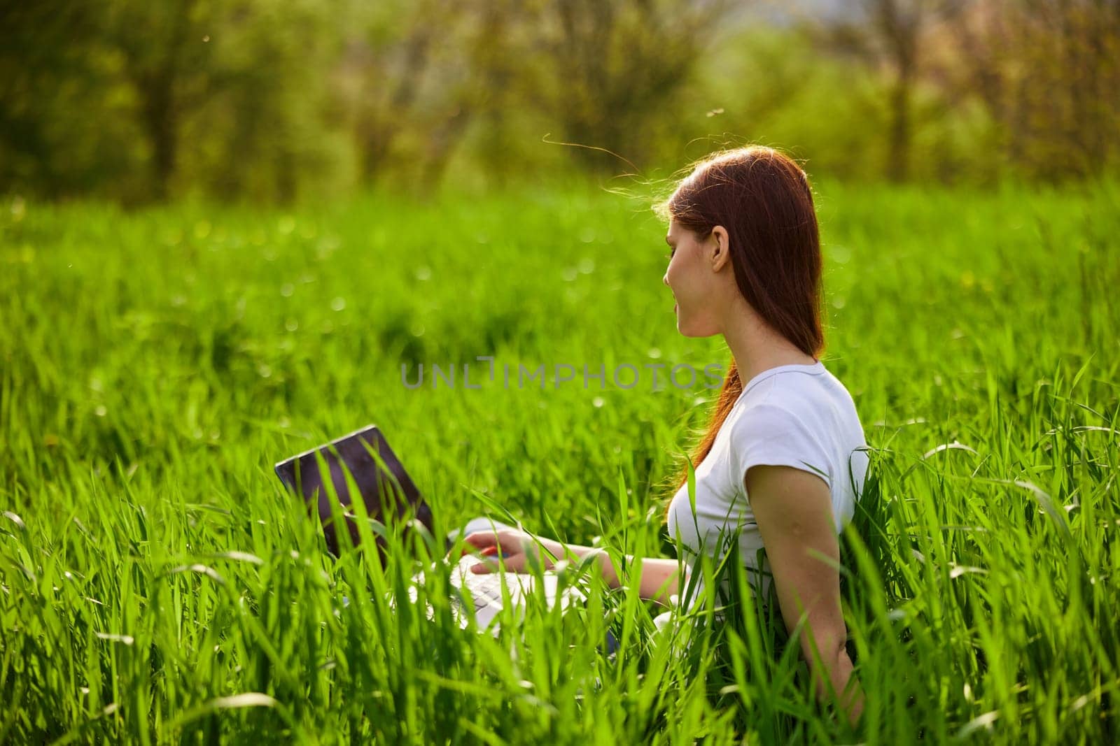 Woman with laptop working in park by Vichizh
