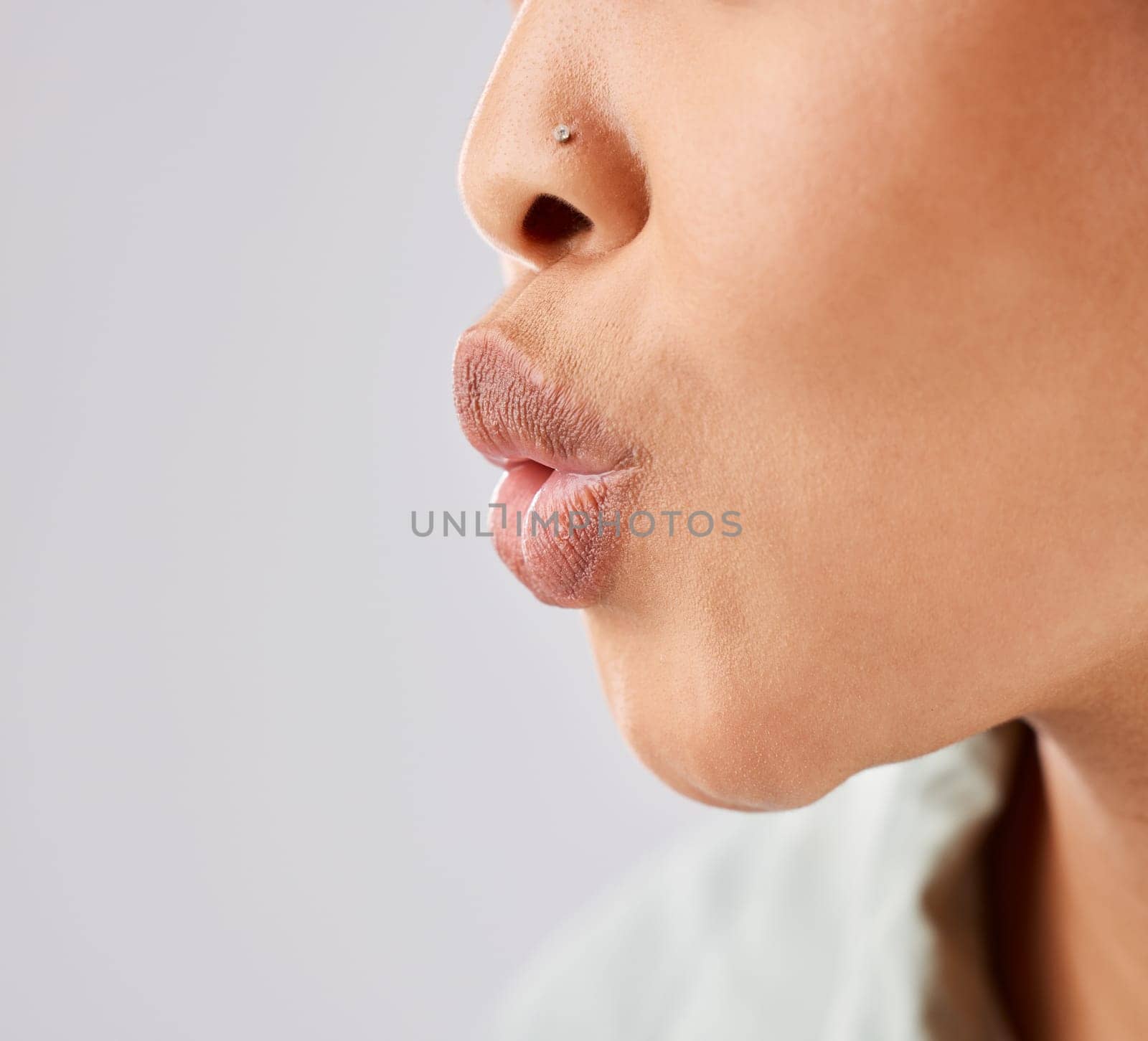 Pout, lips and woman face whistle with her mouth or kiss with lipstick or gloss isolated in a white studio background. Flirting, care and natural lip of a female person showing love, care and romance by YuriArcurs