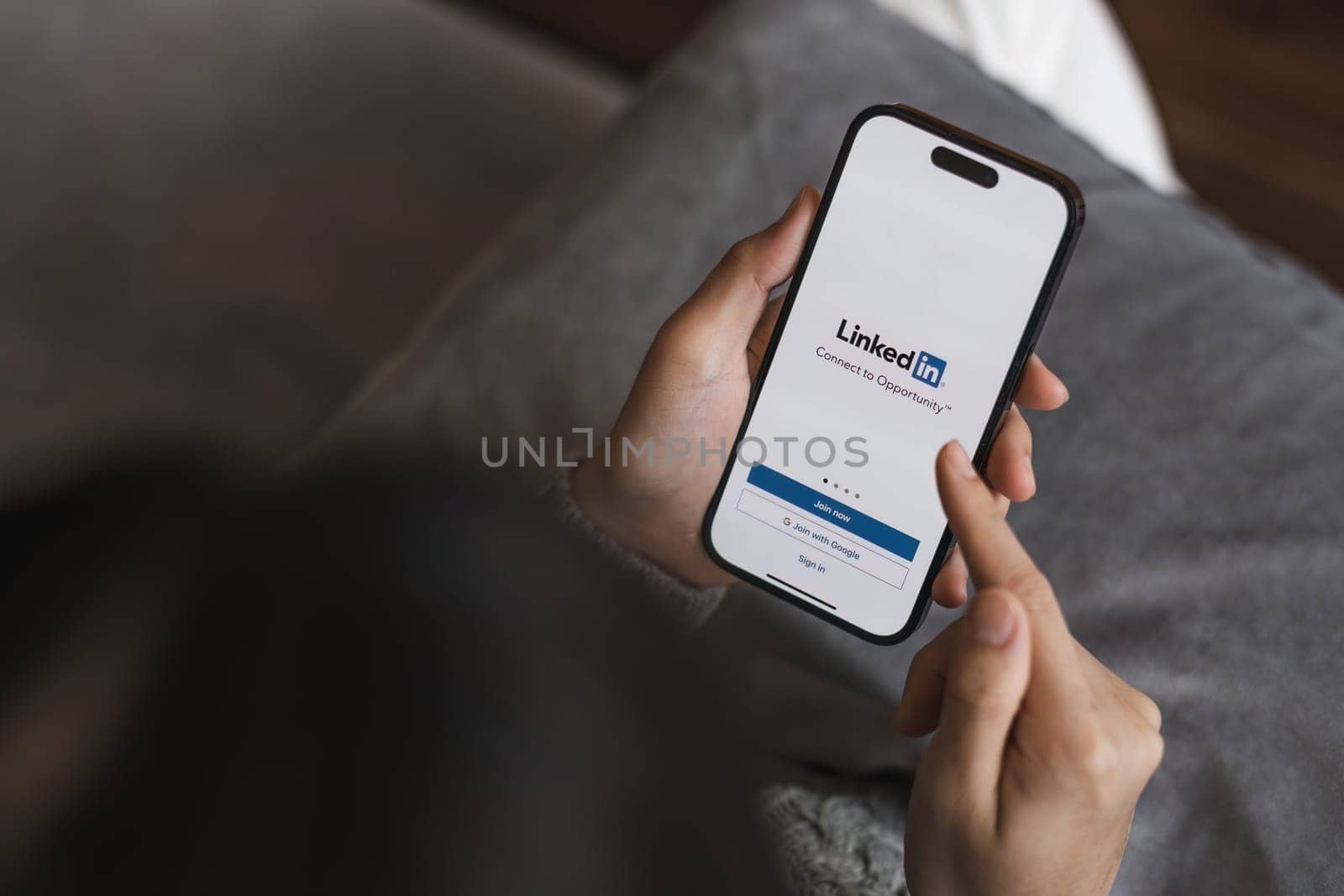 CHIANGMAI, THAILAND - APR 17 2023 : A women holds Apple iPhone 14 with LinkedIn application on the screen.LinkedIn is a photo-sharing app for smartphones...