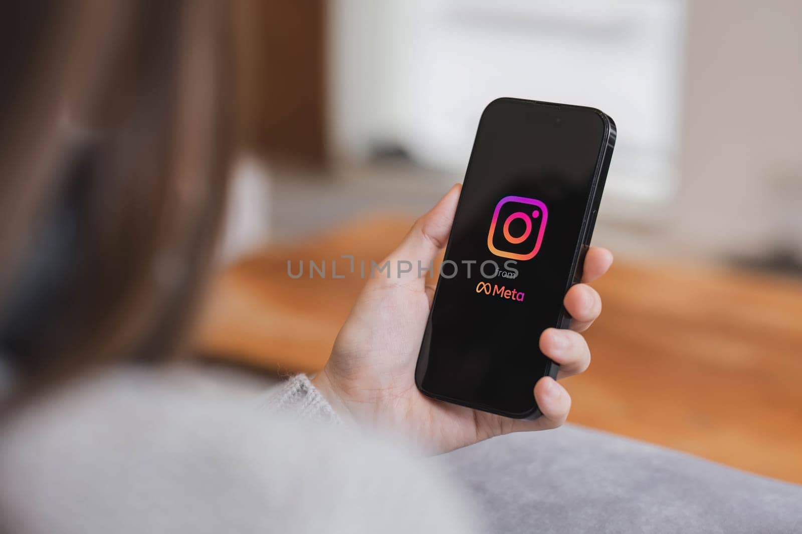 CHIANG MAI, THAILAND - APR 17, 2023: A woman holds Apple iPhone 14 with Instagram application on the screen at cafe. Instagram is a photo-sharing app for smartphones...