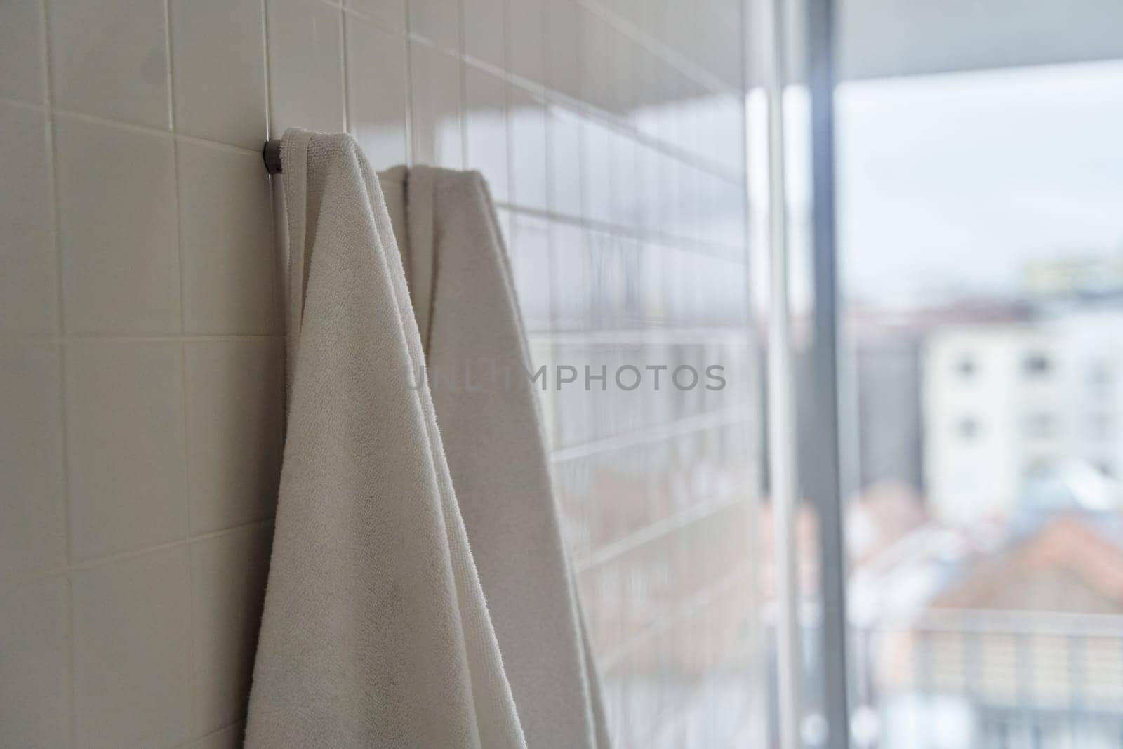 Two white towels hanging in the hotel shower room. High quality photo