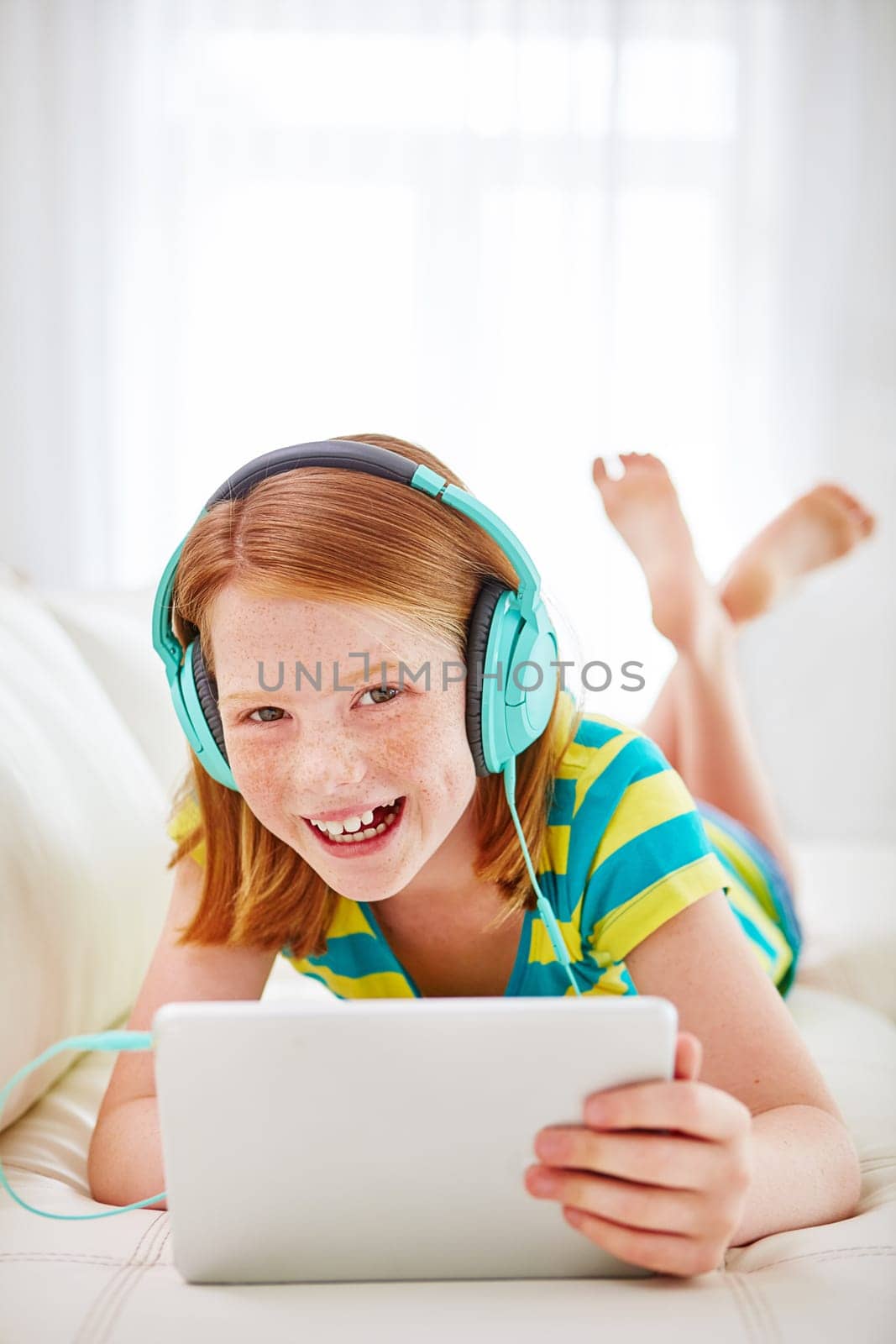 Technology is the coolest ever. a little girl using a digital tablet with headphones at home