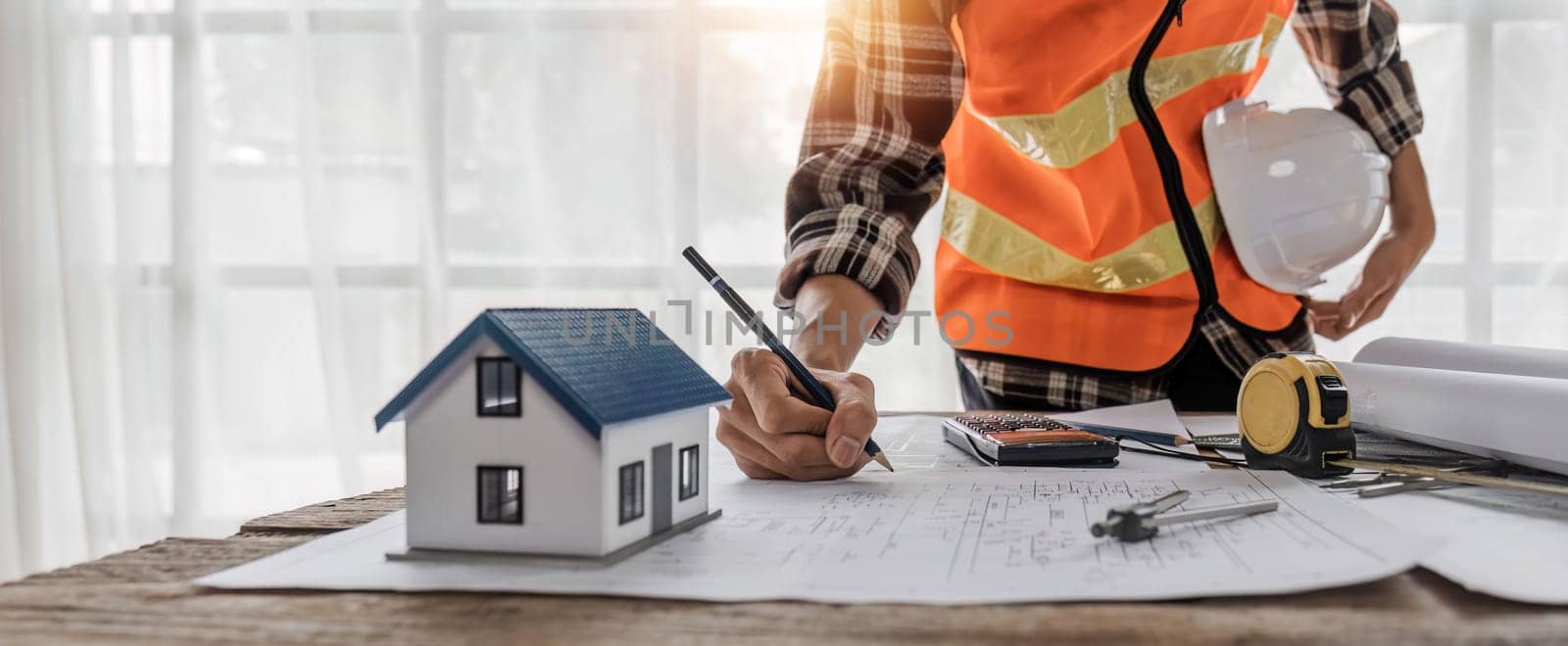 Close up of civil male engineer asian working on blueprint architectural project at construction site at desk in office...