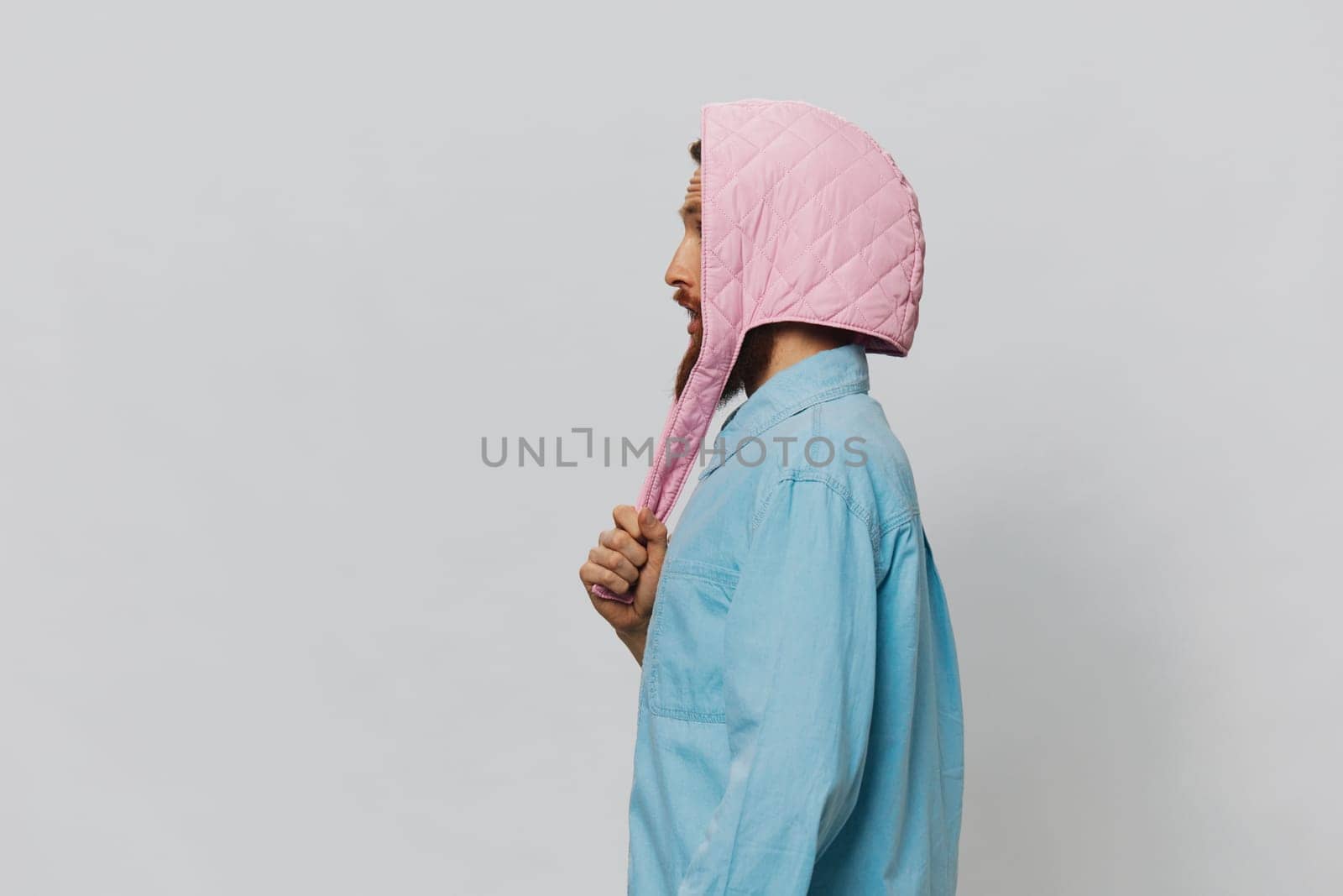 Funny man in a pink hat portrait on a light gray background. Smile and positive emotions. High quality photo