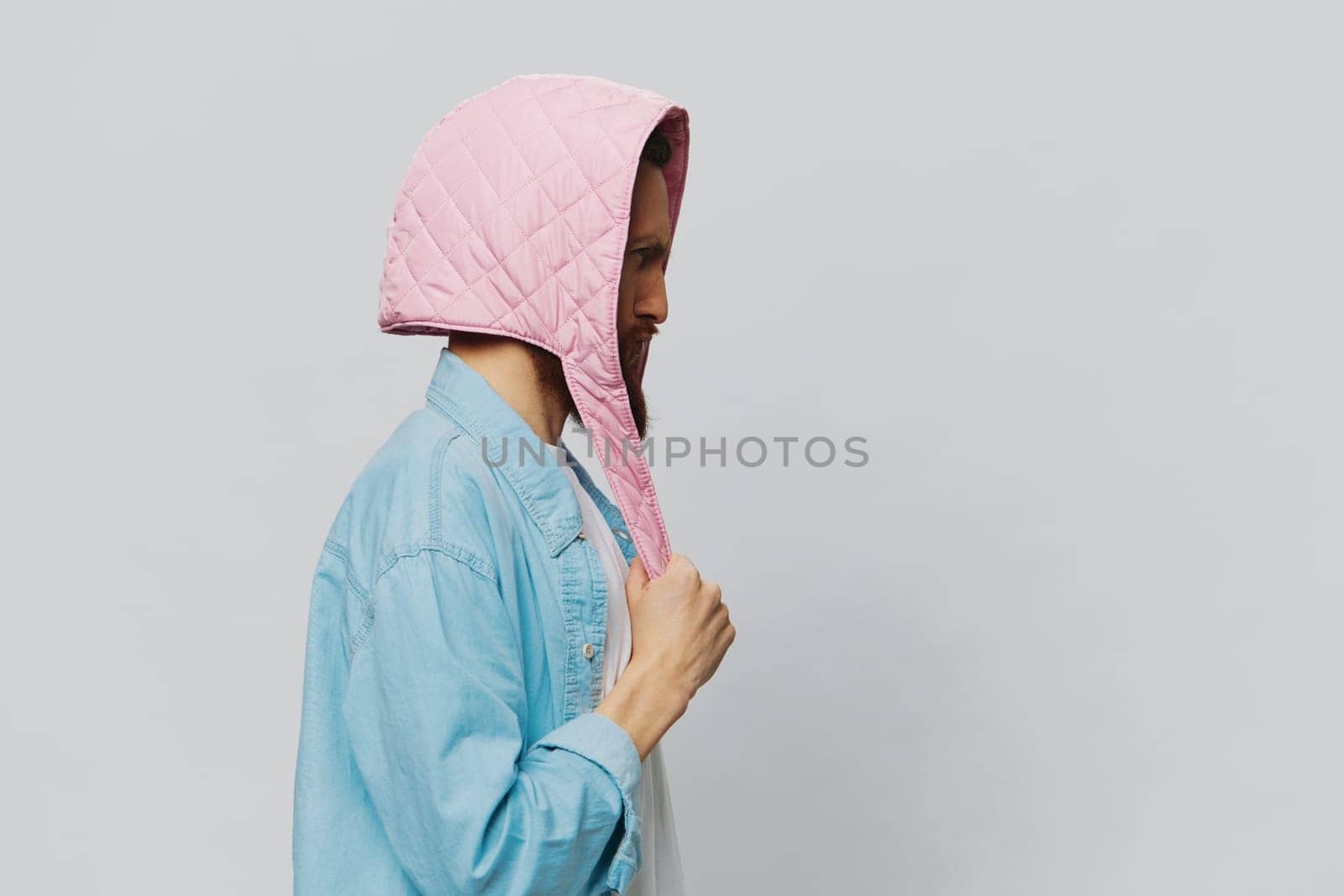 Funny man in a pink hat portrait on a light gray background. Smile and positive emotions. High quality photo