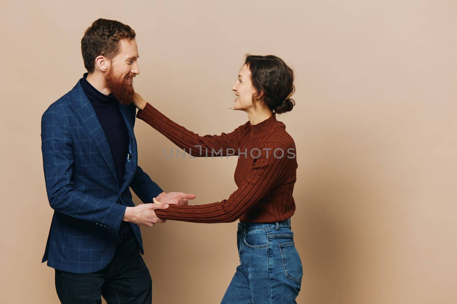 Man and woman couple in a relationship smile and interaction on a beige background in a real relationship between people. High quality photo