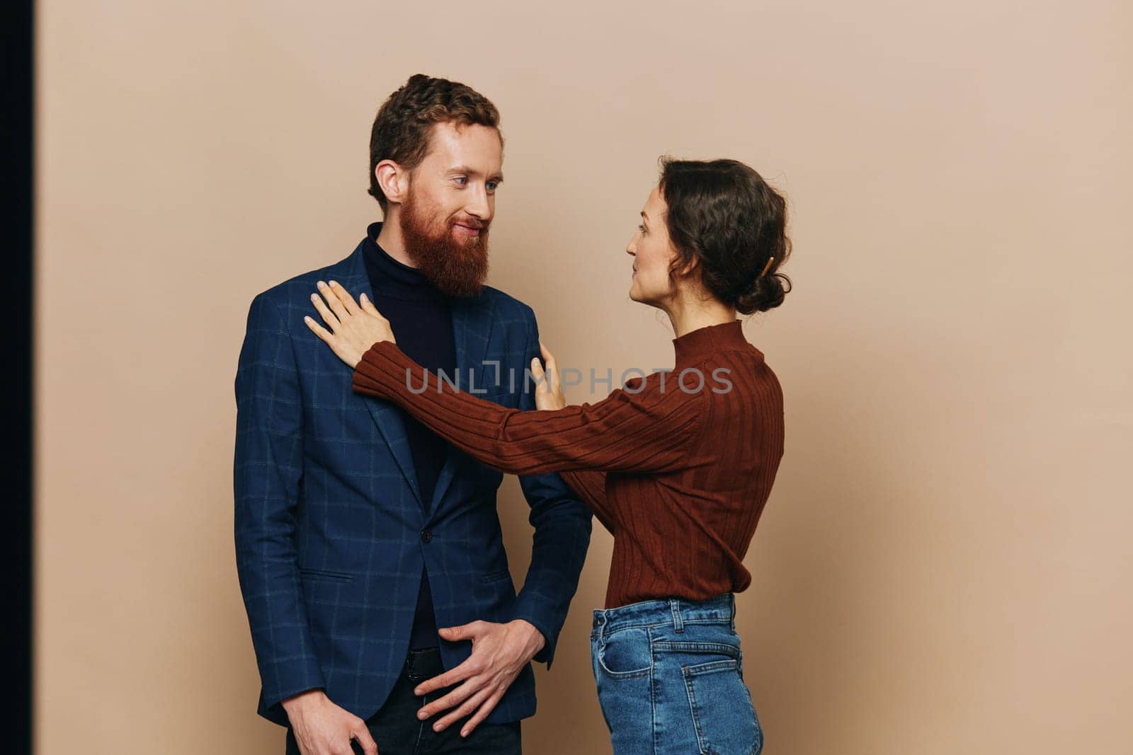 Man and woman couple in a relationship smile and interaction on a beige background in a real relationship between people. High quality photo