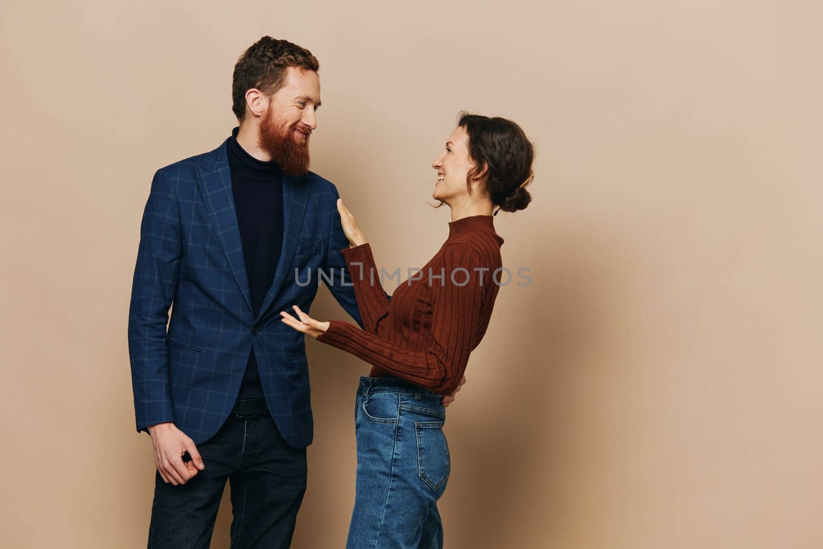 Man and woman couple in a relationship smile and interaction on a beige background in a real relationship between people. High quality photo