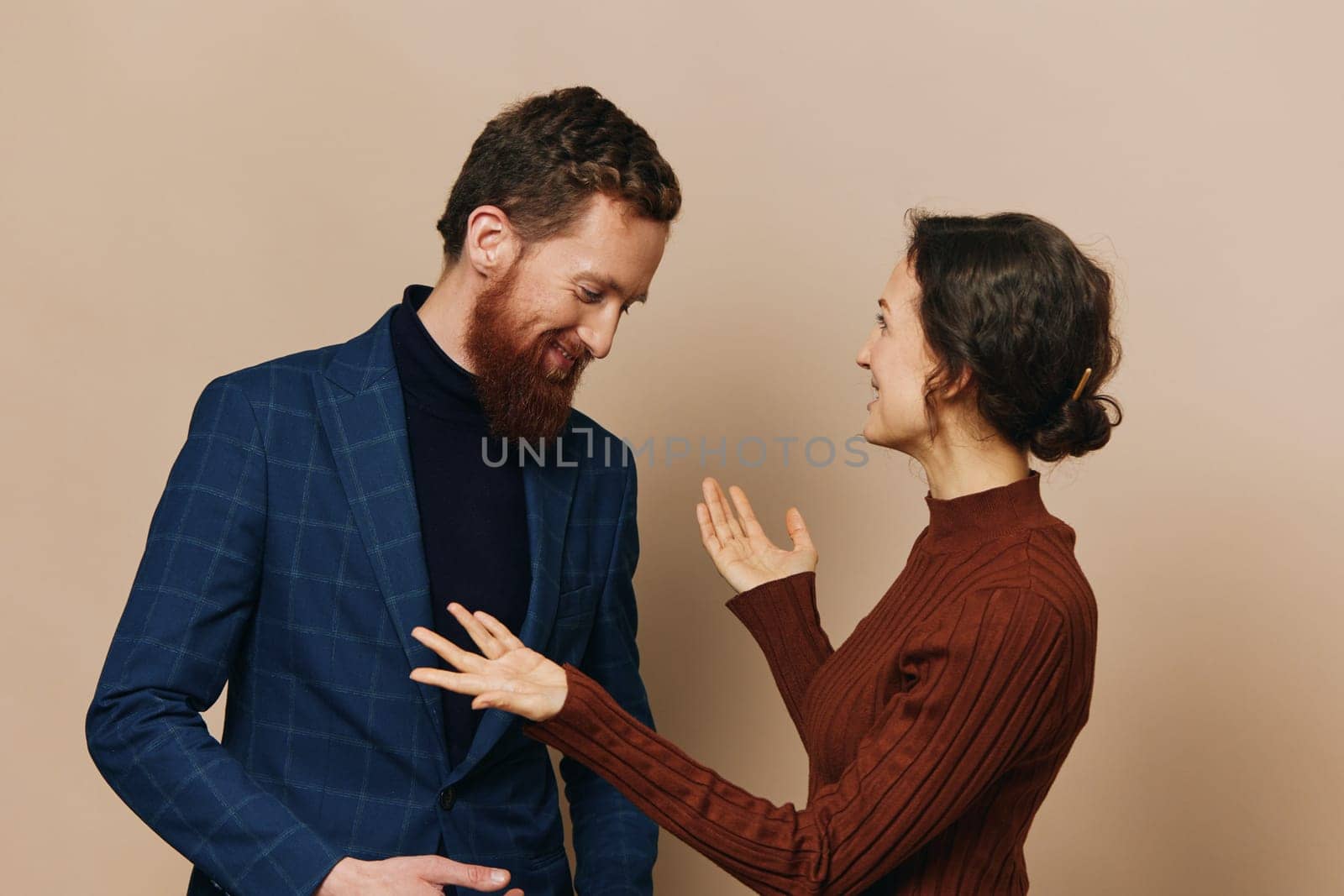 Man and woman couple in a relationship smile and interaction on a beige background in a real relationship between people. High quality photo