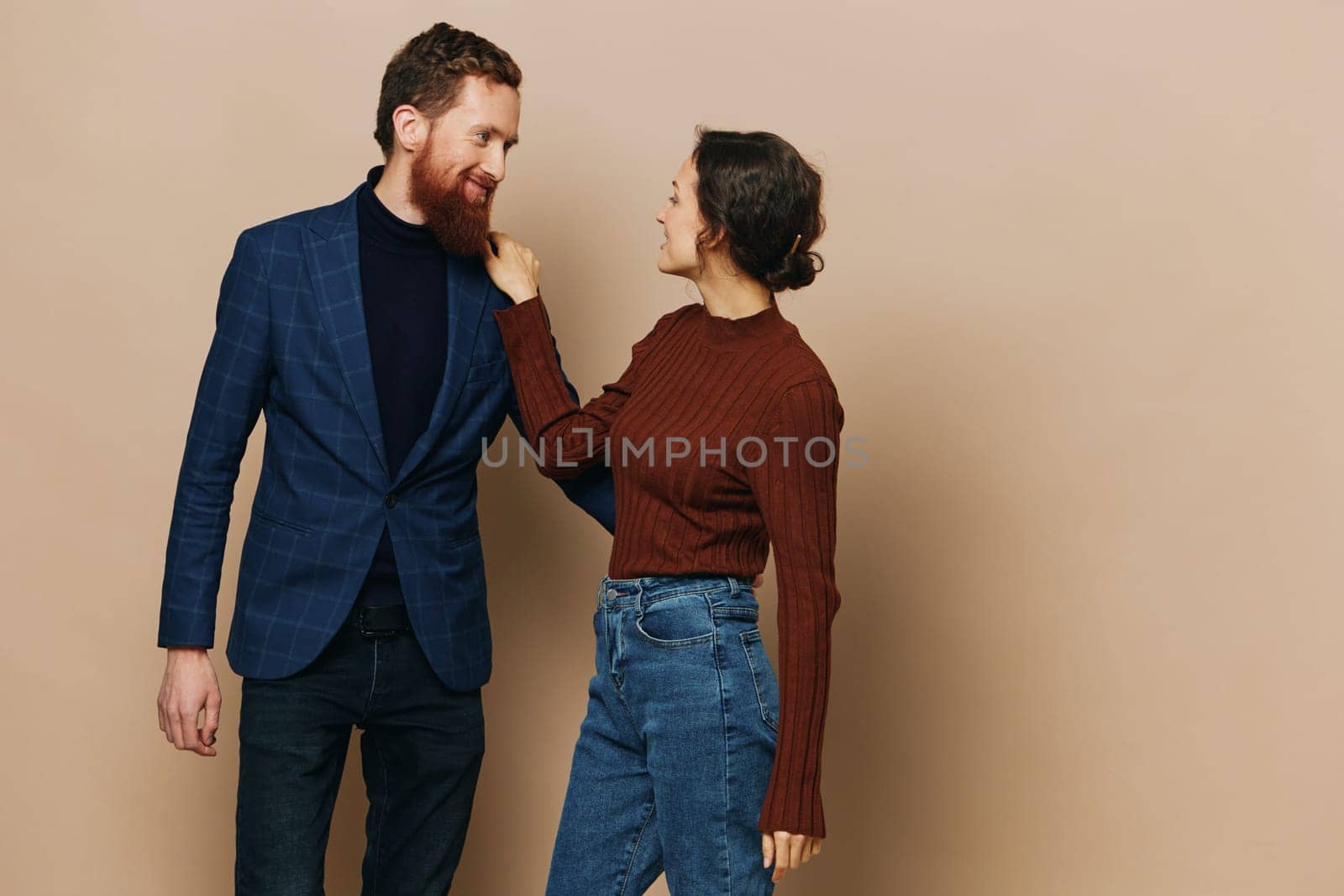 Man and woman couple in a relationship smile and interaction on a beige background in a real relationship between people. High quality photo