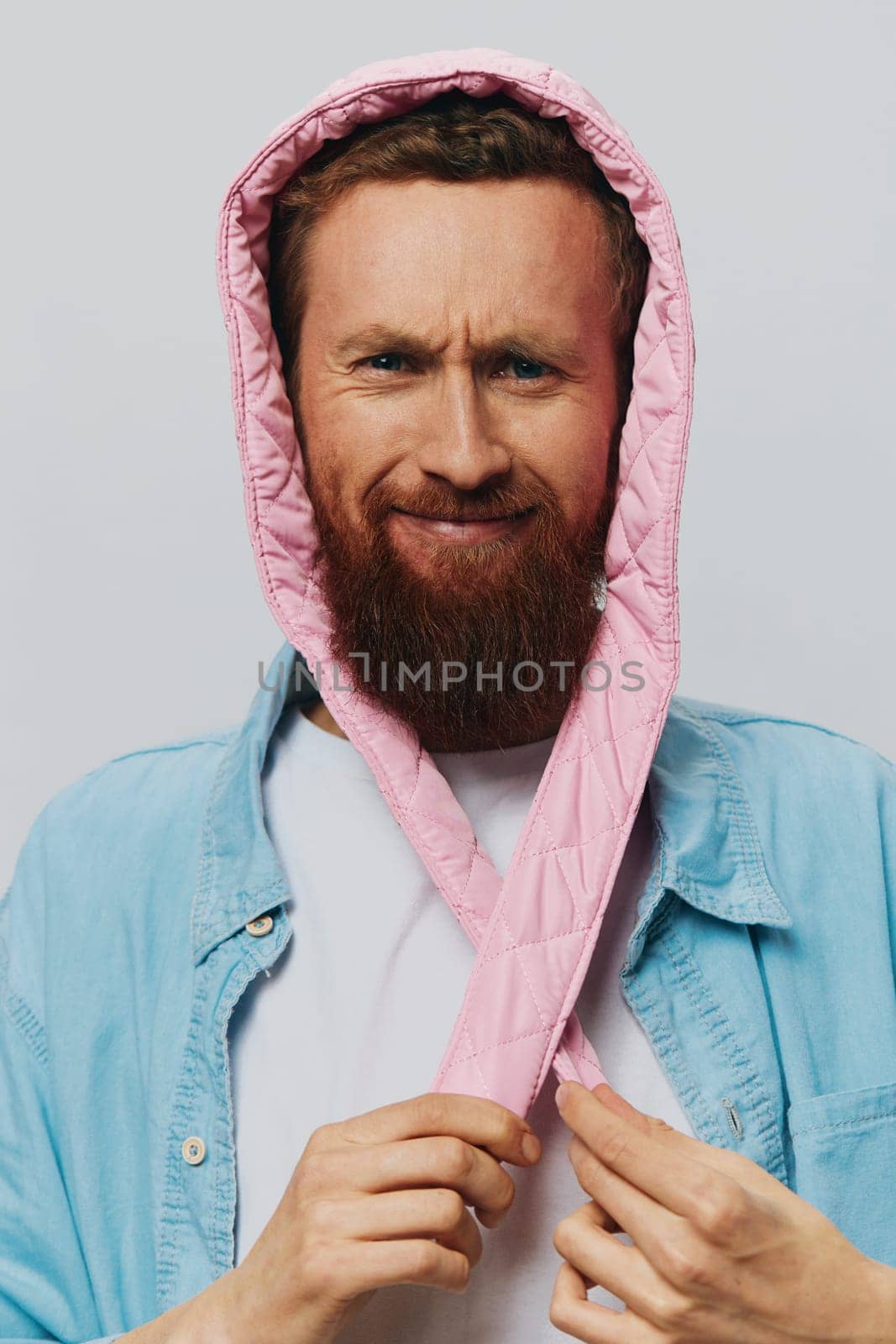 Funny man in a pink hat portrait on a light gray background. Smile and positive emotions. High quality photo