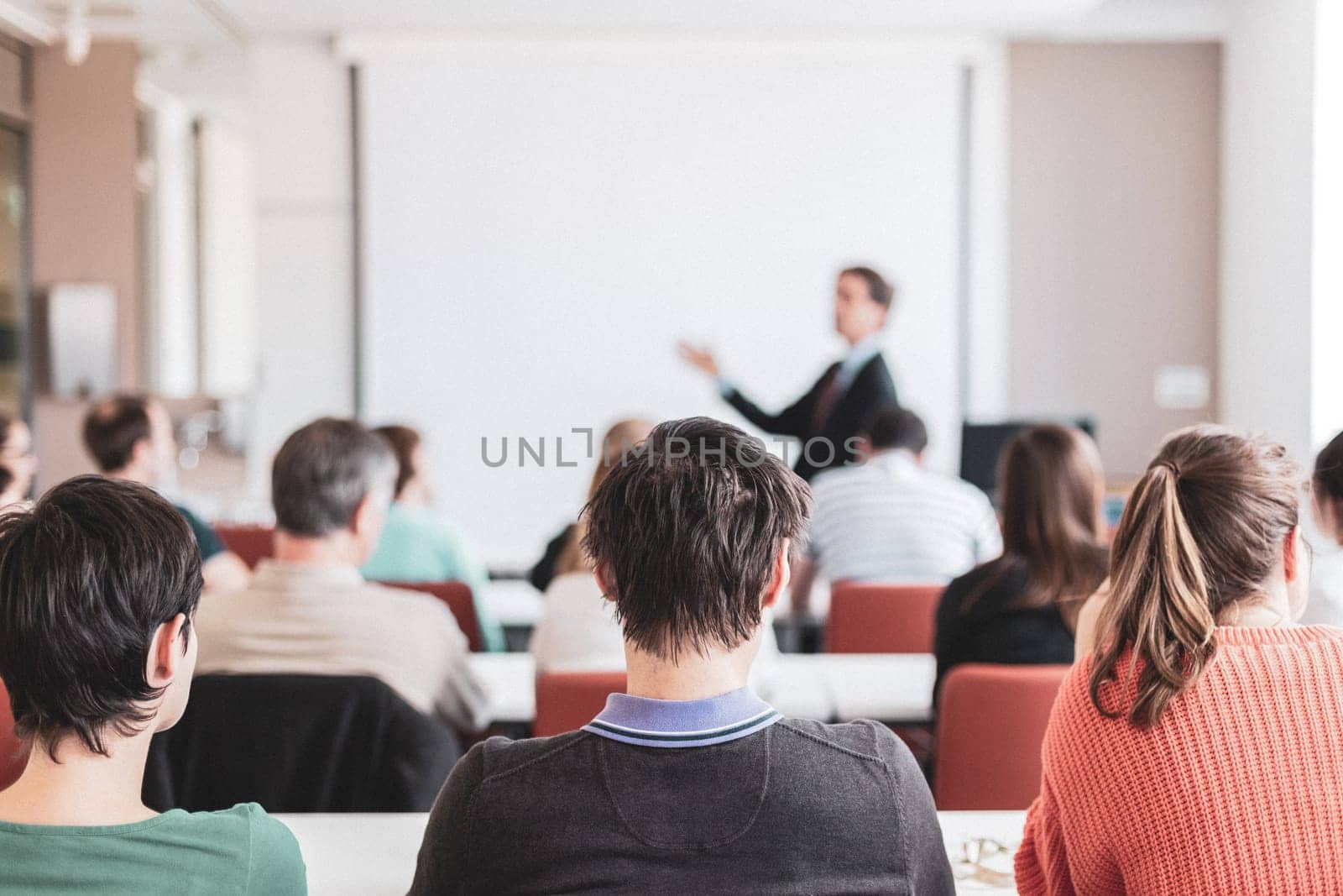 Speaker Giving a Talk at Business Meeting. Audience in the conference hall. Business and Entrepreneurship. Copy space on white board by kasto