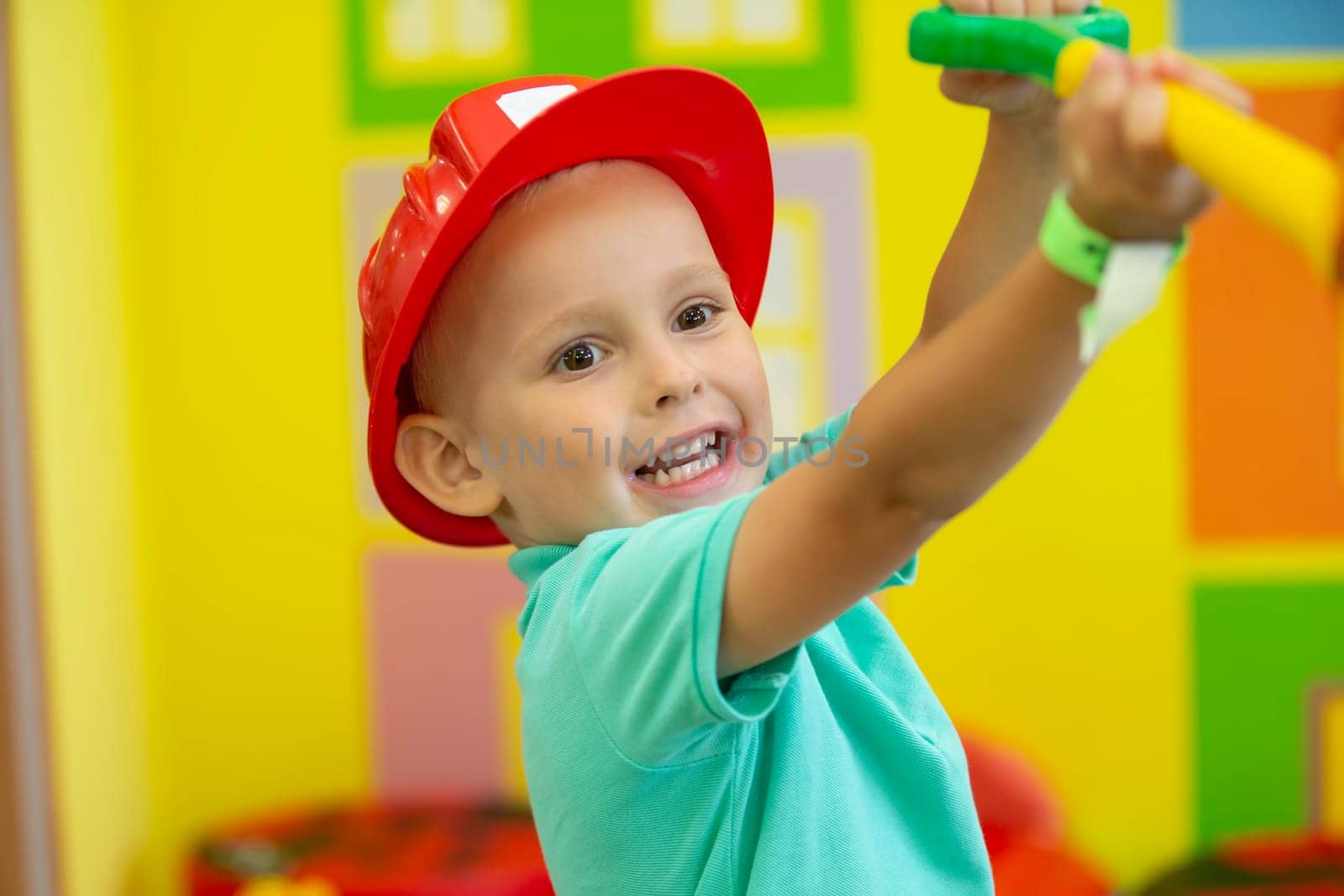 A little boy in a protective helmet plays a builder. by Sviatlana