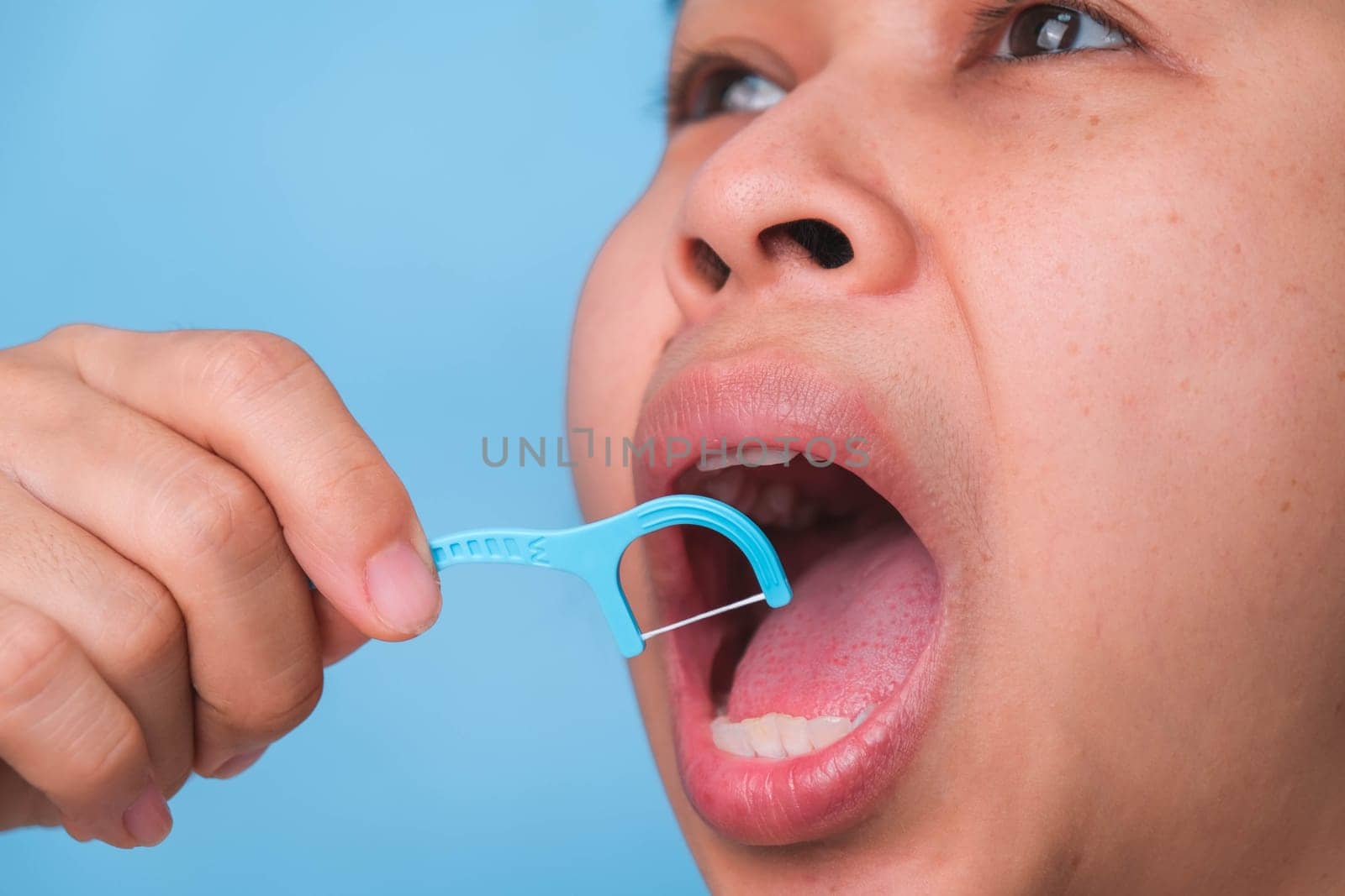 Close-up of smiling asian woman and cleaning for perfect smile. Healthy white teeth by flossing, oral health and dental care.