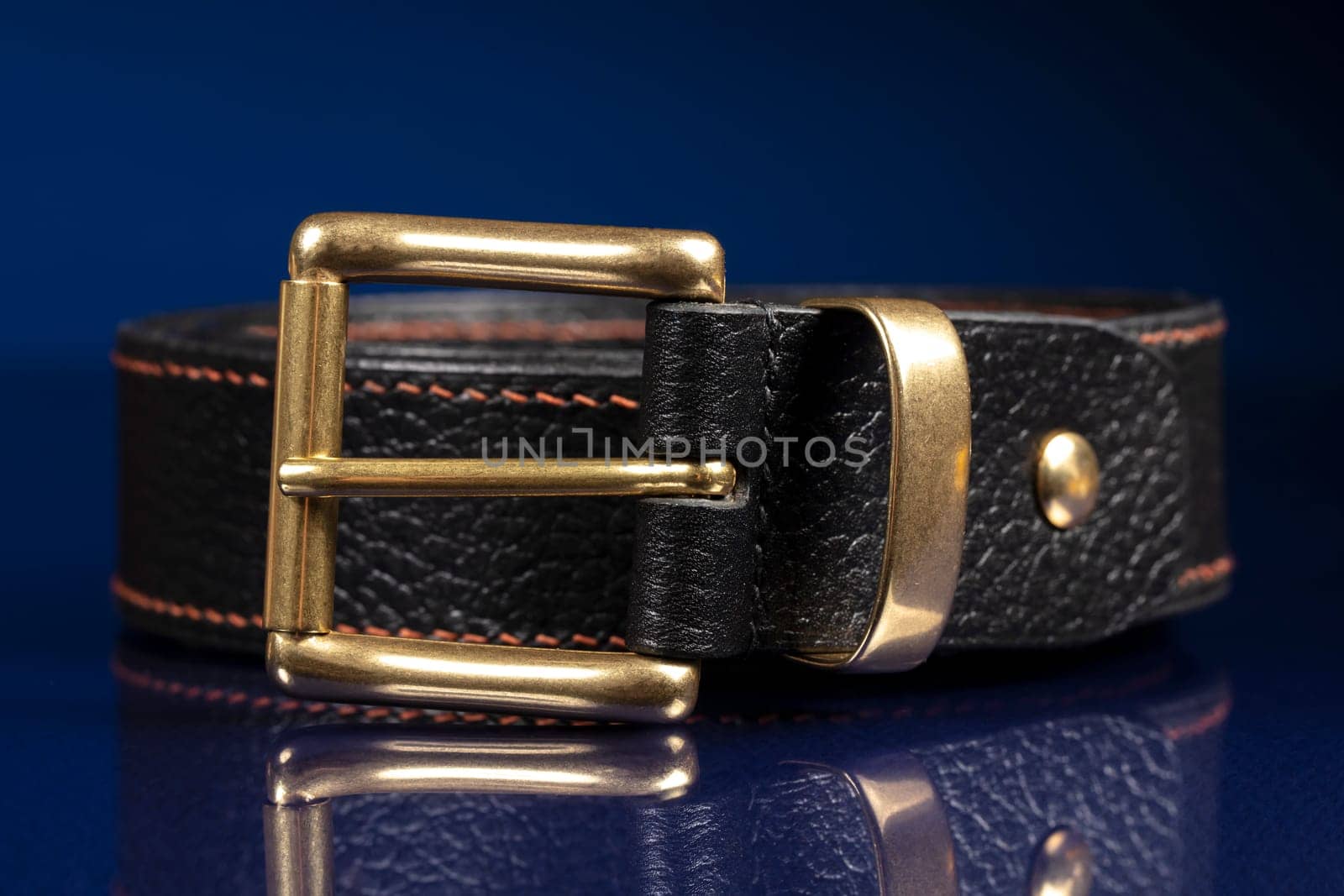 Black leather belt on a dark blue background. by Sviatlana