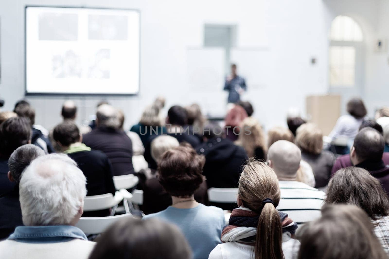 Speaker Giving a Talk at Business Meeting. Audience in the conference hall. Business and Entrepreneurship. Copy space on white board.