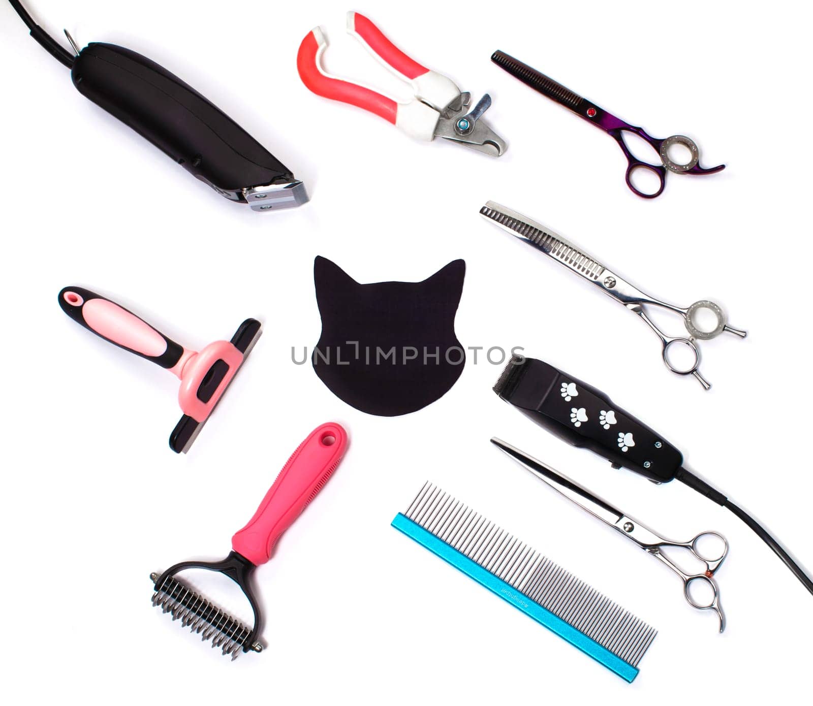 Tool for the groomer on a white background. Accessories for dog and cat care. Scissors for cutting animals. View from above.A fabric-cut cat's face surrounded by a grooming tool.