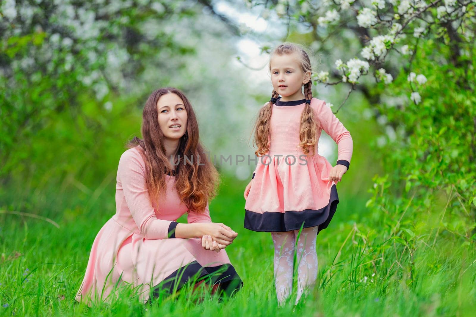 mother and daughter in nature in identical dresses