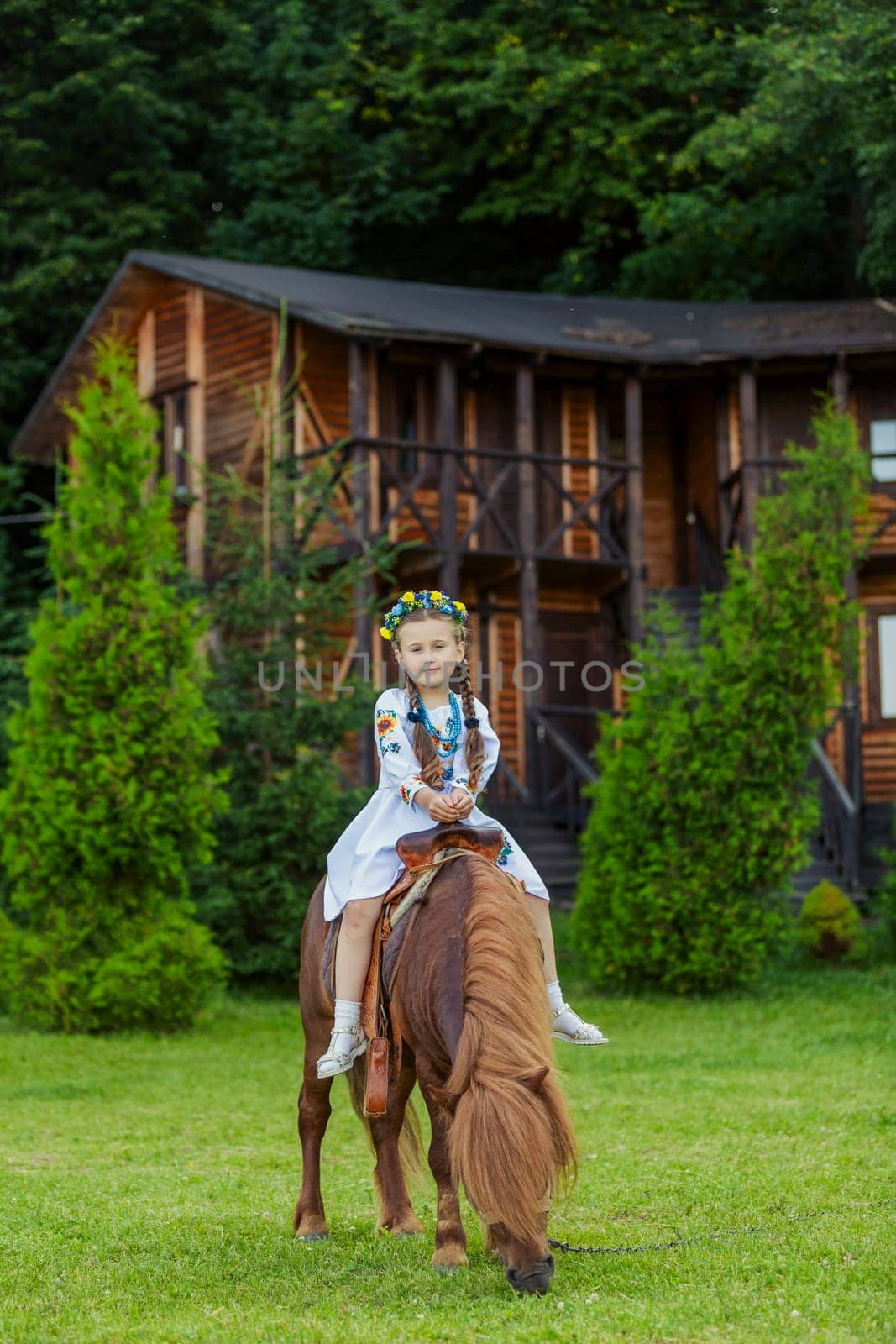 Little girl in Ukrainian national costume rides a pony by zokov