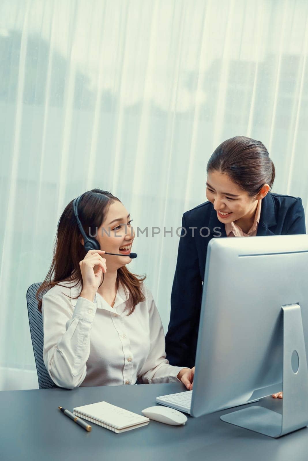 Asian female customer support operator guided by manger Enthusiastic by biancoblue