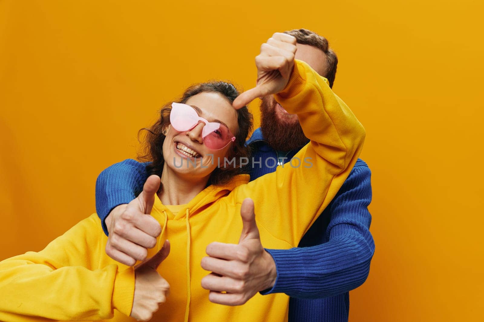 Man and woman couple smiling cheerfully and crooked with glasses, on yellow background, symbols signs and hand gestures, family shoot, newlyweds. by SHOTPRIME