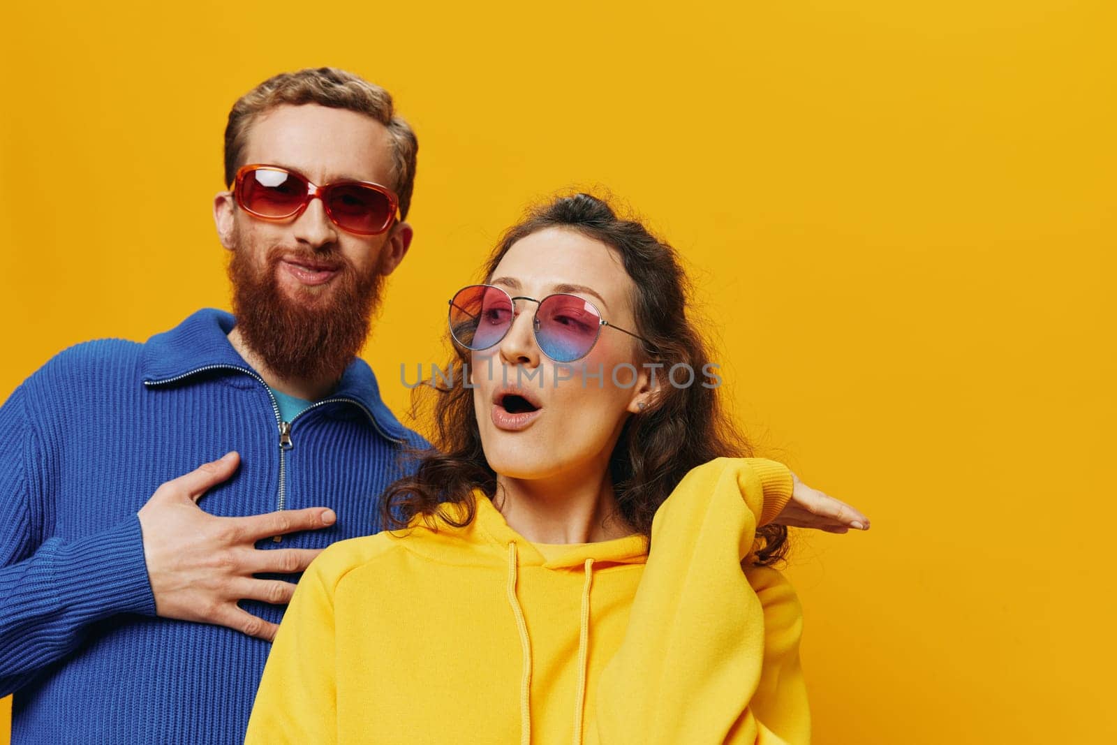 Man and woman couple smiling cheerfully and crooked with glasses, on yellow background, symbols signs and hand gestures, family shoot, newlyweds. High quality photo