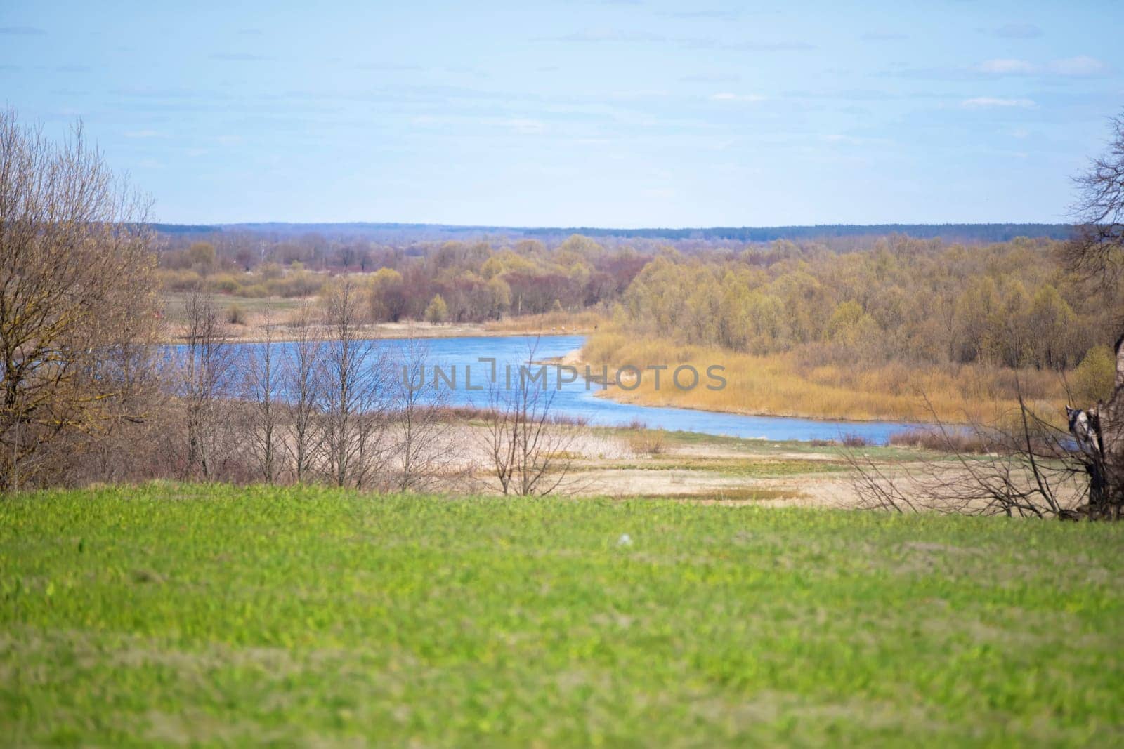 A beautiful landscape of flat terrain with forest meadows and a blue river.