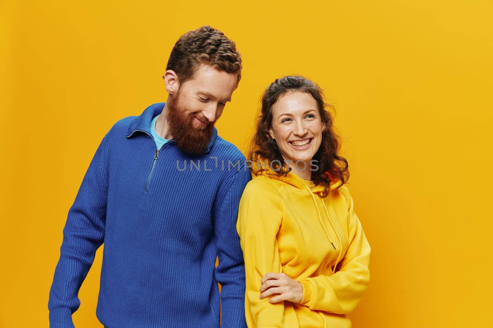 Man and woman couple smiling cheerfully and crooked with glasses, on yellow background, symbols signs and hand gestures, family shoot, newlyweds. High quality photo