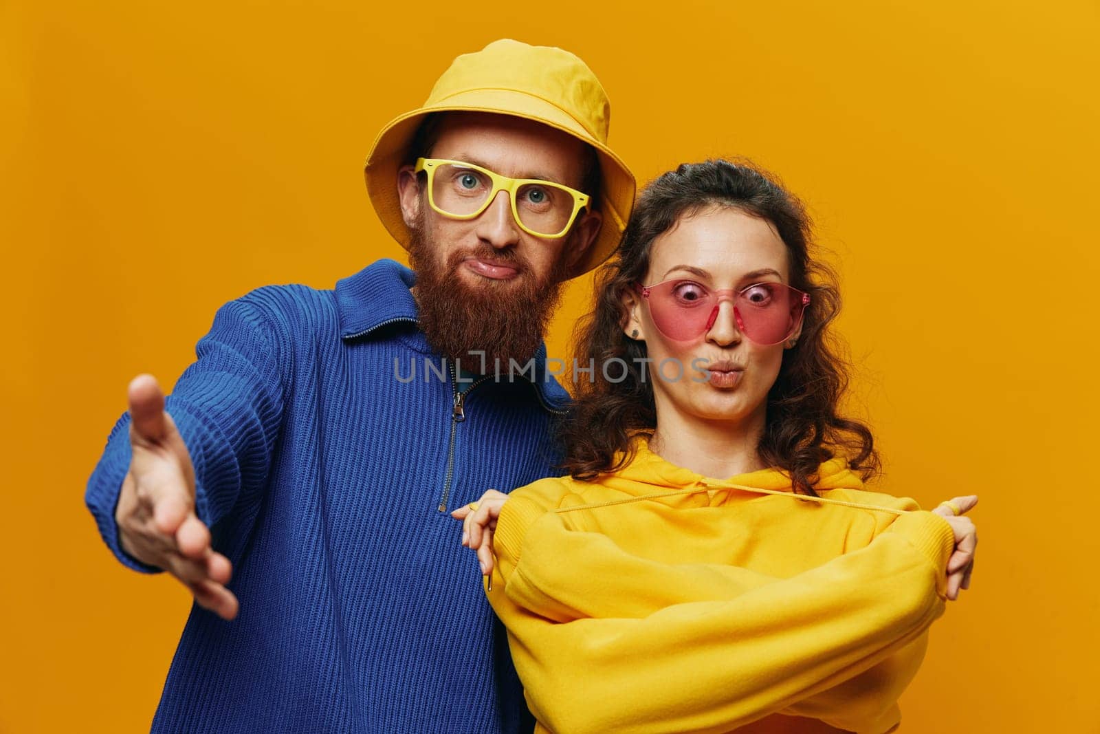 Woman and man smiling, suitcases in hand with yellow and red suitcase smiling merrily and crooked, yellow background, going on a trip, family vacation trip, newlyweds. by SHOTPRIME