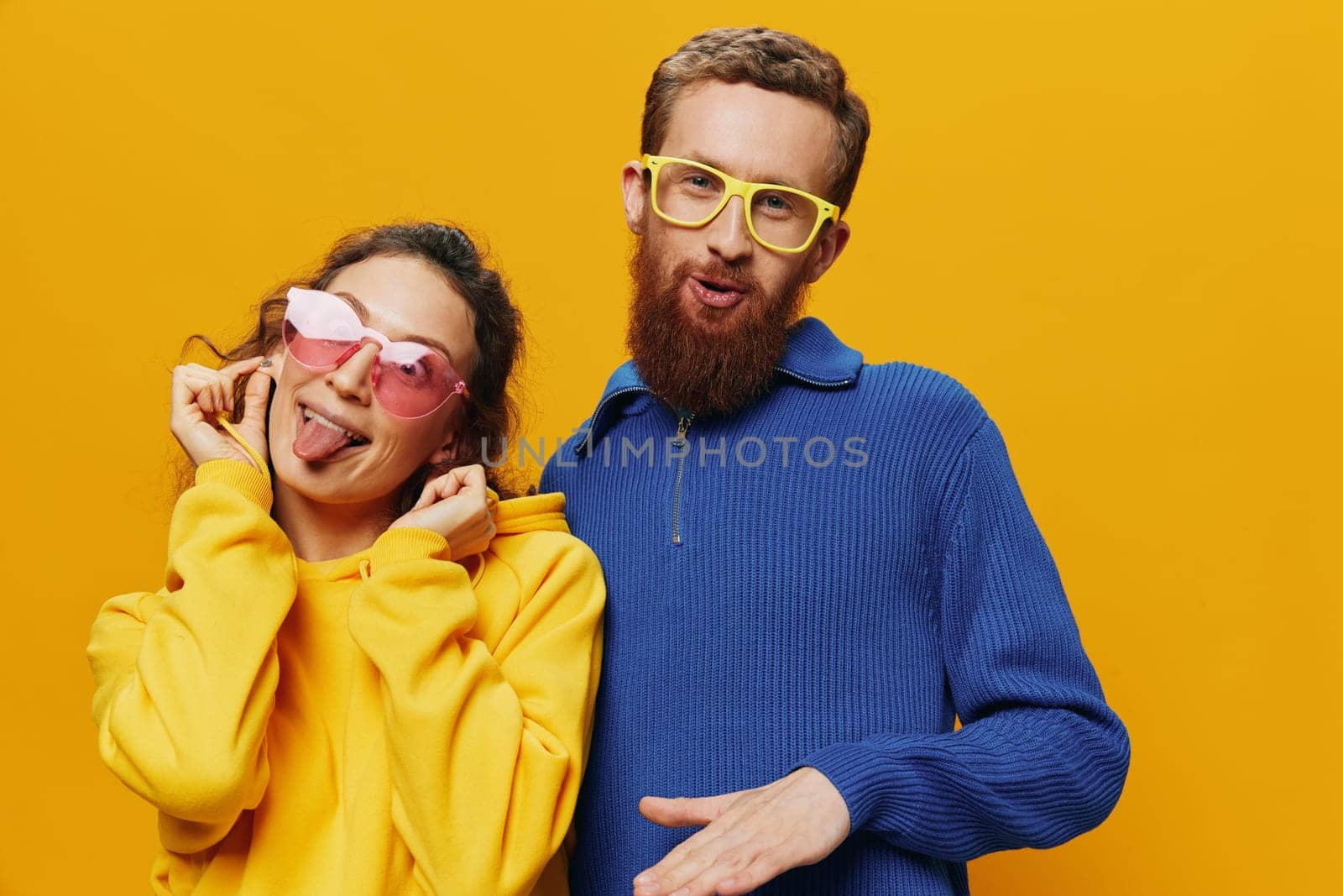 Man and woman couple smiling cheerfully and crooked with glasses, on yellow background, symbols signs and hand gestures, family shoot, newlyweds. by SHOTPRIME