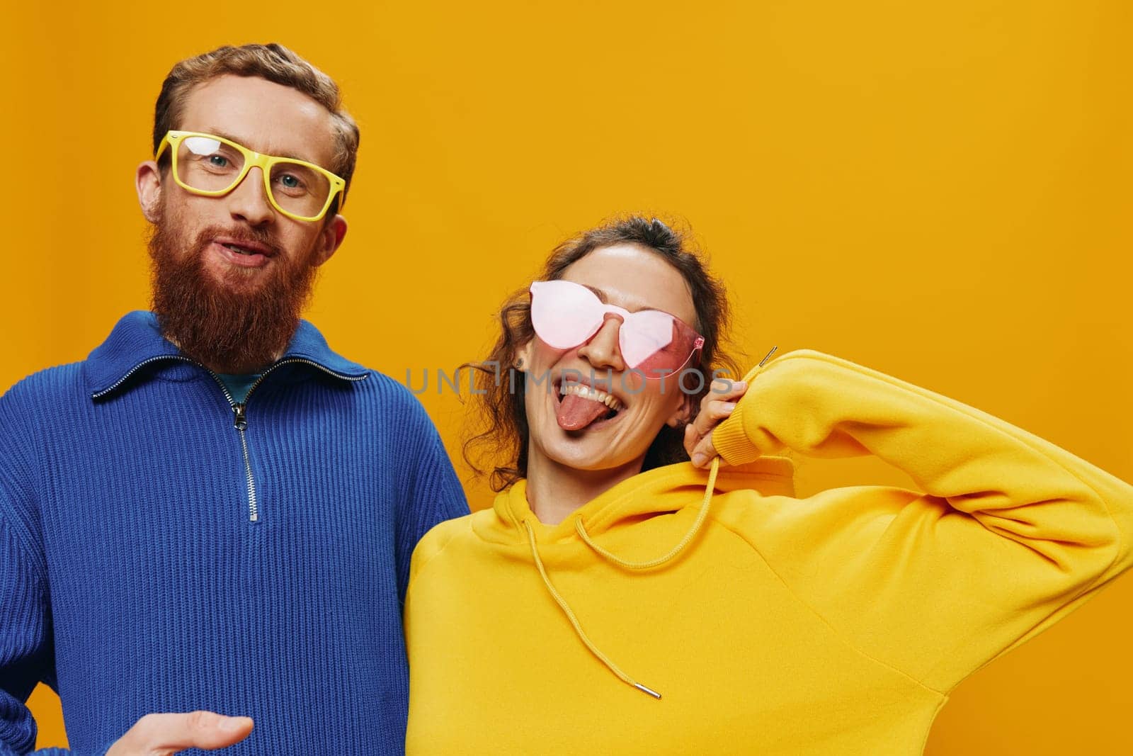 Man and woman couple smiling cheerfully and crooked with glasses, on yellow background, symbols signs and hand gestures, family shoot, newlyweds. by SHOTPRIME