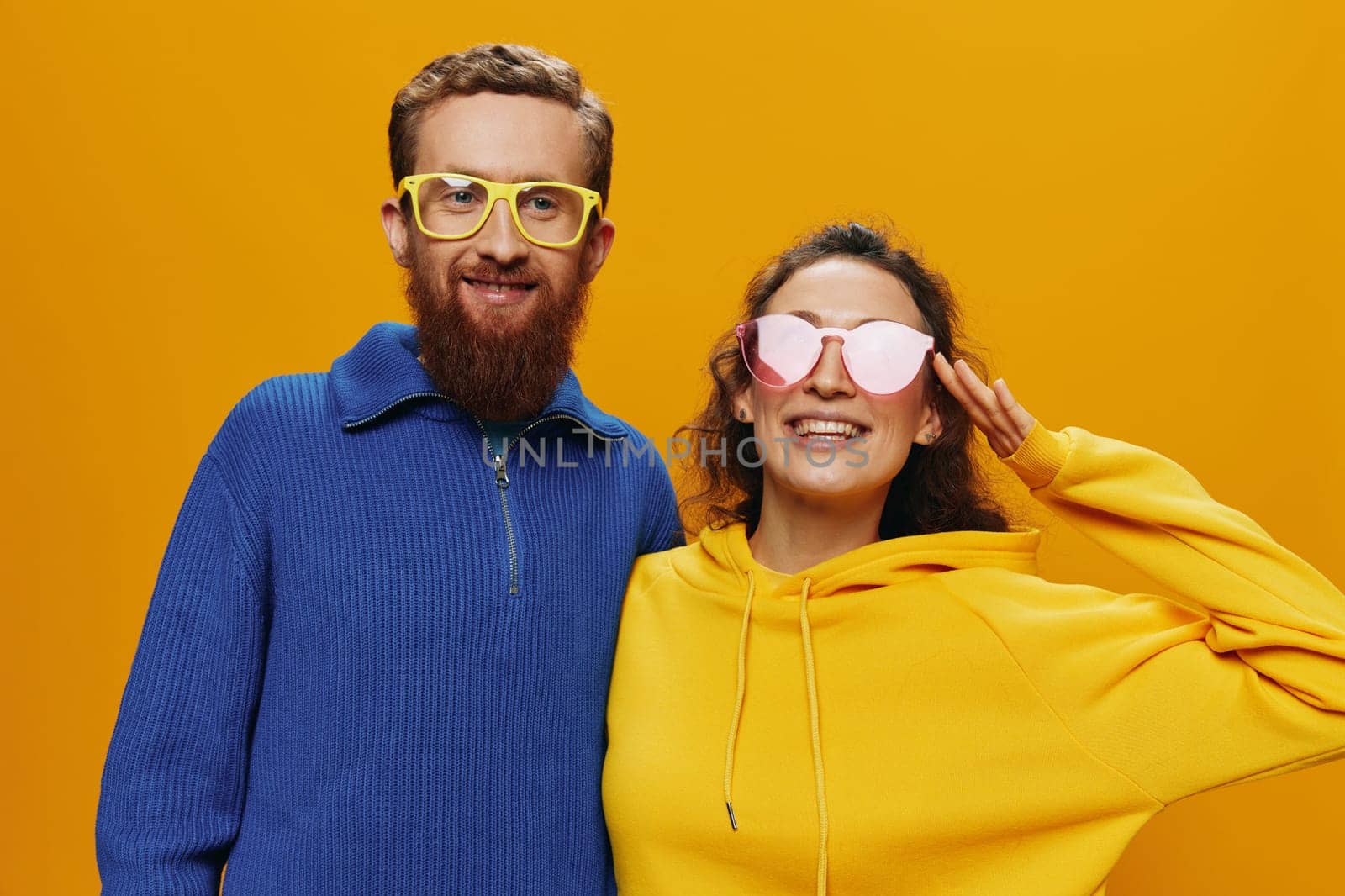 Man and woman couple smiling cheerfully and crooked with glasses, on yellow background, symbols signs and hand gestures, family shoot, newlyweds. by SHOTPRIME