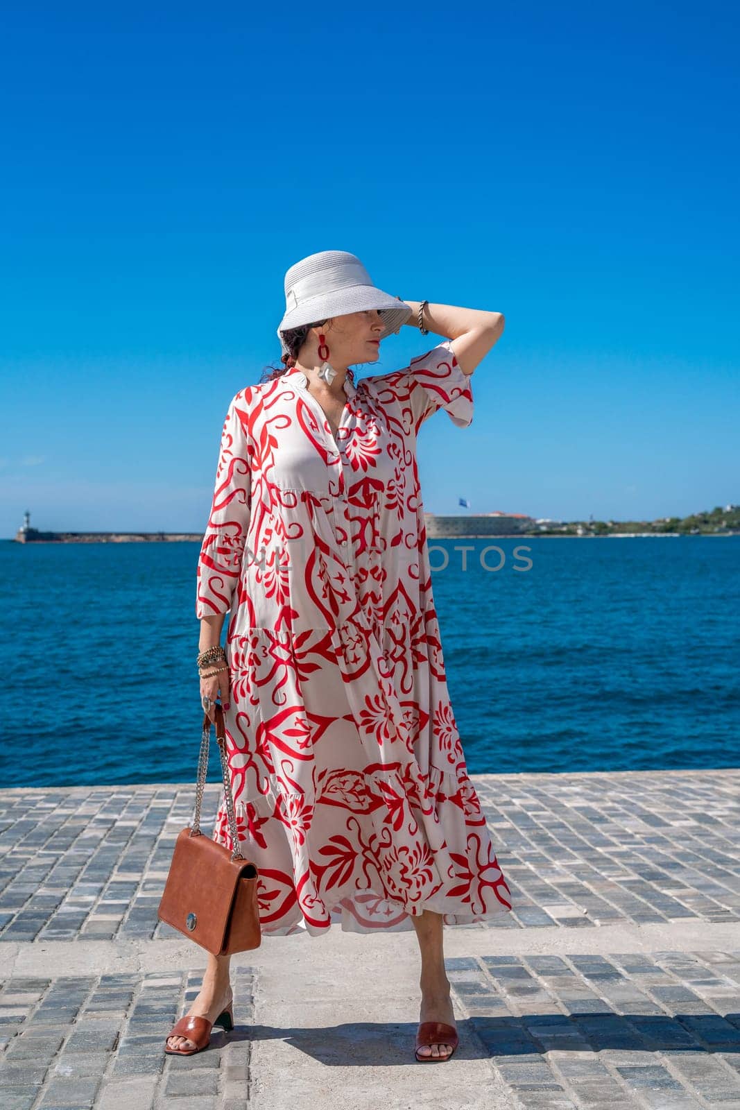 woman in a hat and dress enjoys the blue sea and summer. Welcome summer. by Matiunina