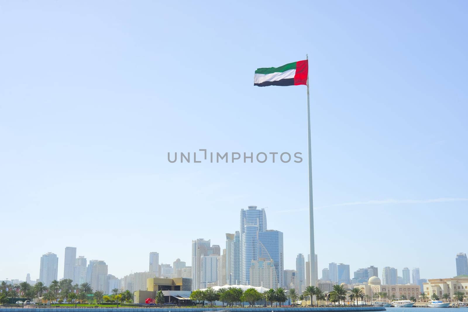 SHARJAH, UAE - February 14, 2023: Flag of the United Arab Emirates in Sharjah on the coastline by Ekaterina34