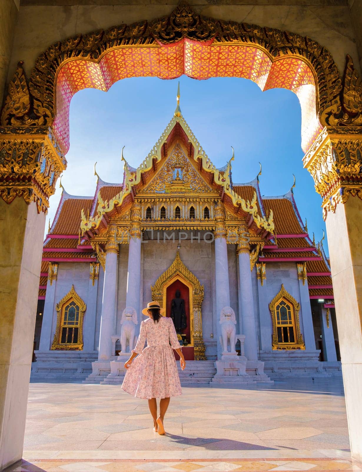 a Asian woman walking at Wat Benchamabophit temple in Bangkok Thailand, The Marble temple in Bangkok. Asian woman with a hat visiting a temple in Bangkok