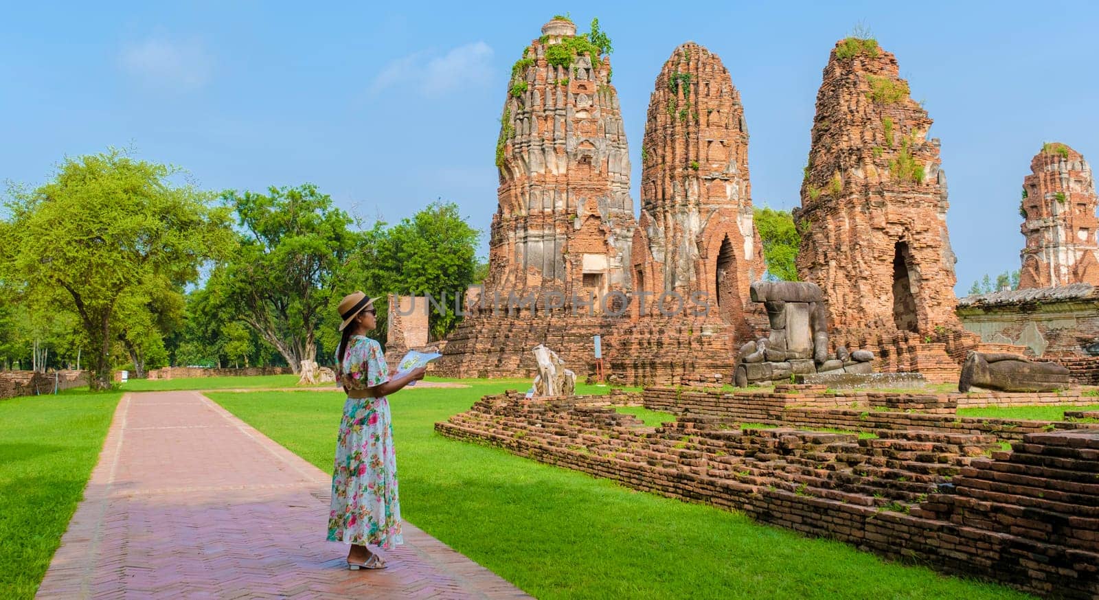 Ayutthaya, Thailand at Wat Mahathat, women with a hat and tourist maps visiting Ayutthaya Thailand. Tourists with map of Thailand