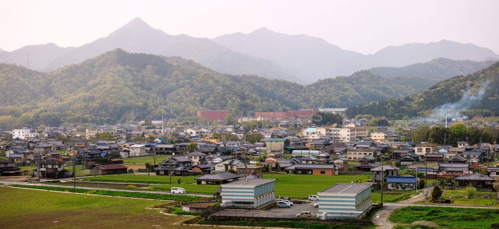 Apartments and houses in small town in rural valley between mountains by Osaze