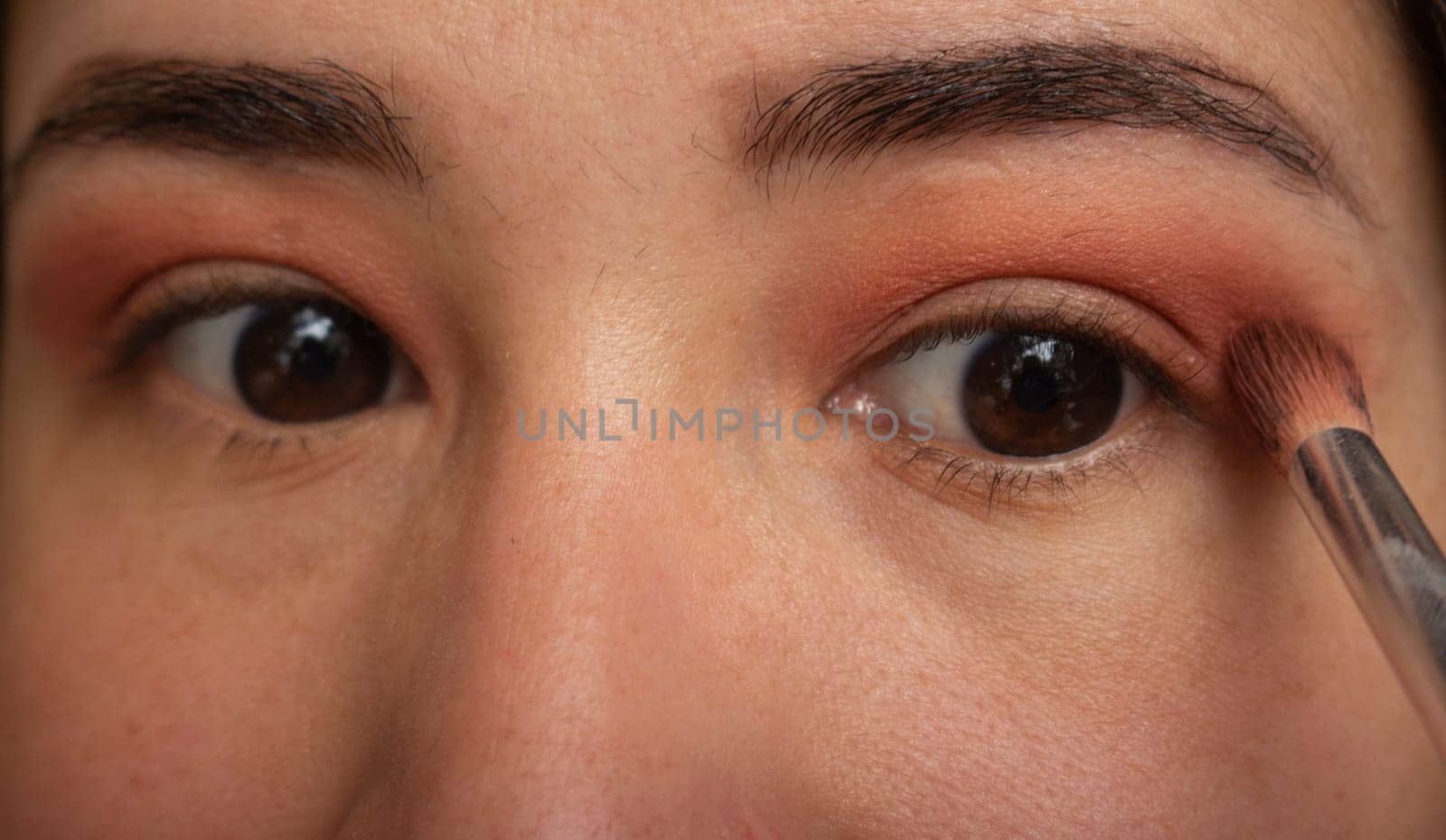 closeup of blonde girl putting makeup on her eyes. High quality photo