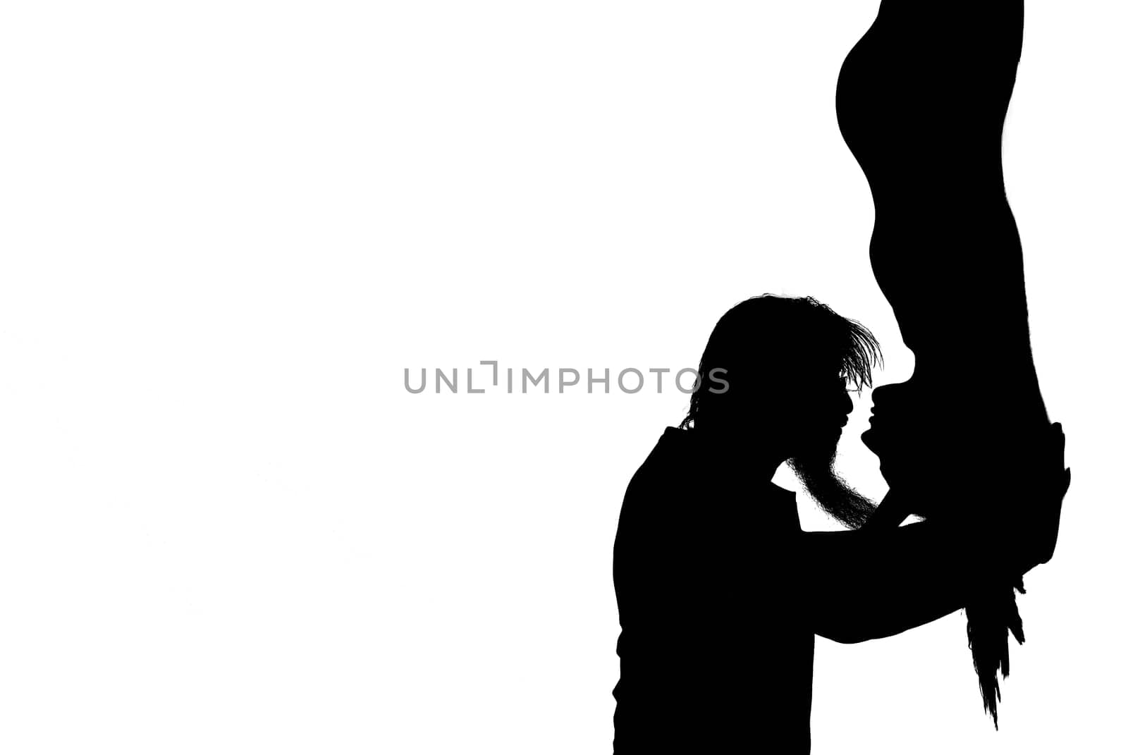 Beautiful pregnant woman and her handsome husband are kissing while spending time together isolated over white background wall. beautiful young couple expecting baby standing together and touching belly
