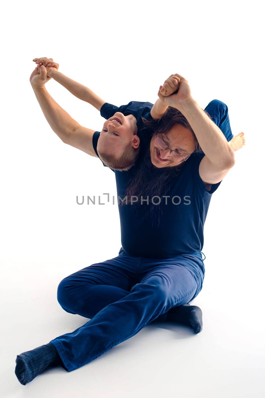 young handsome father with his son fooling around, lifestyle on white background. High quality photo