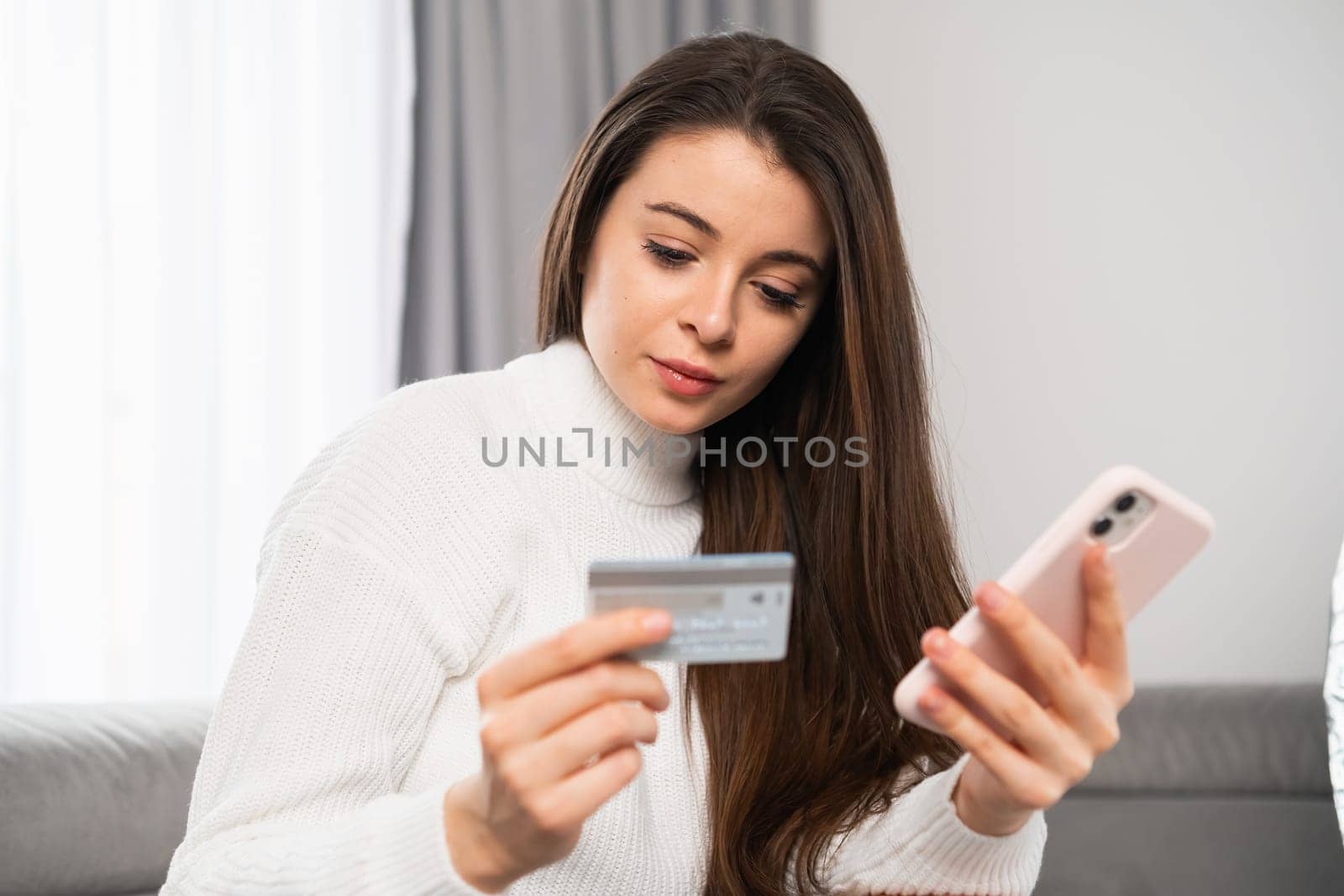 Shot of a young beautiful woman holding a credit card and shopping online.