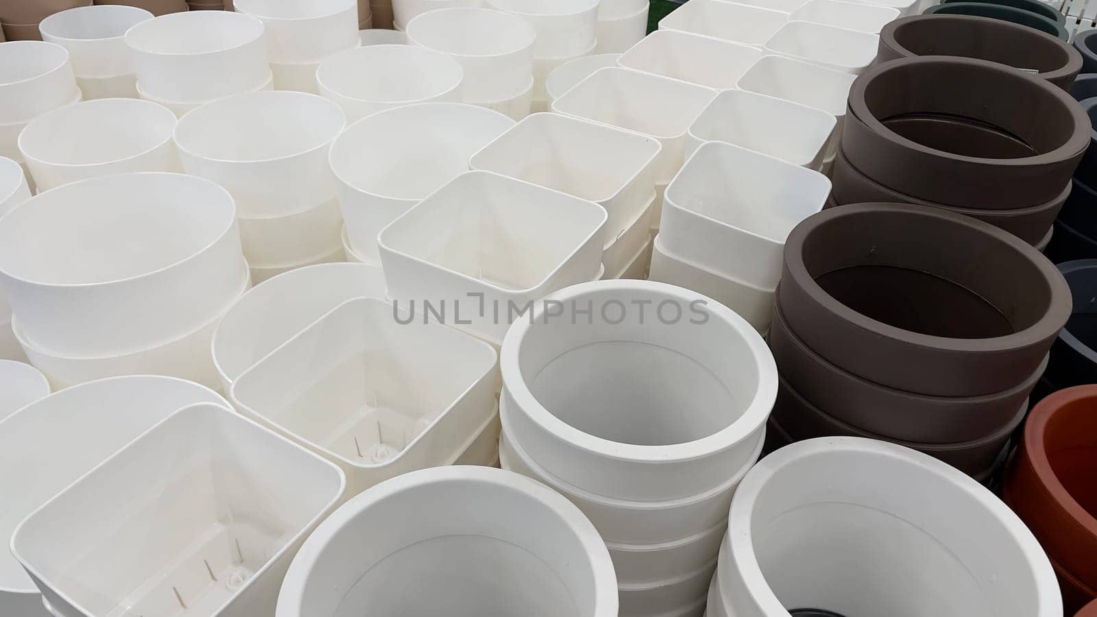 Close-up of empty flower pots in a store or greenhouse. Colorful pots for plants. Gardening and landscape design concept by Matiunina